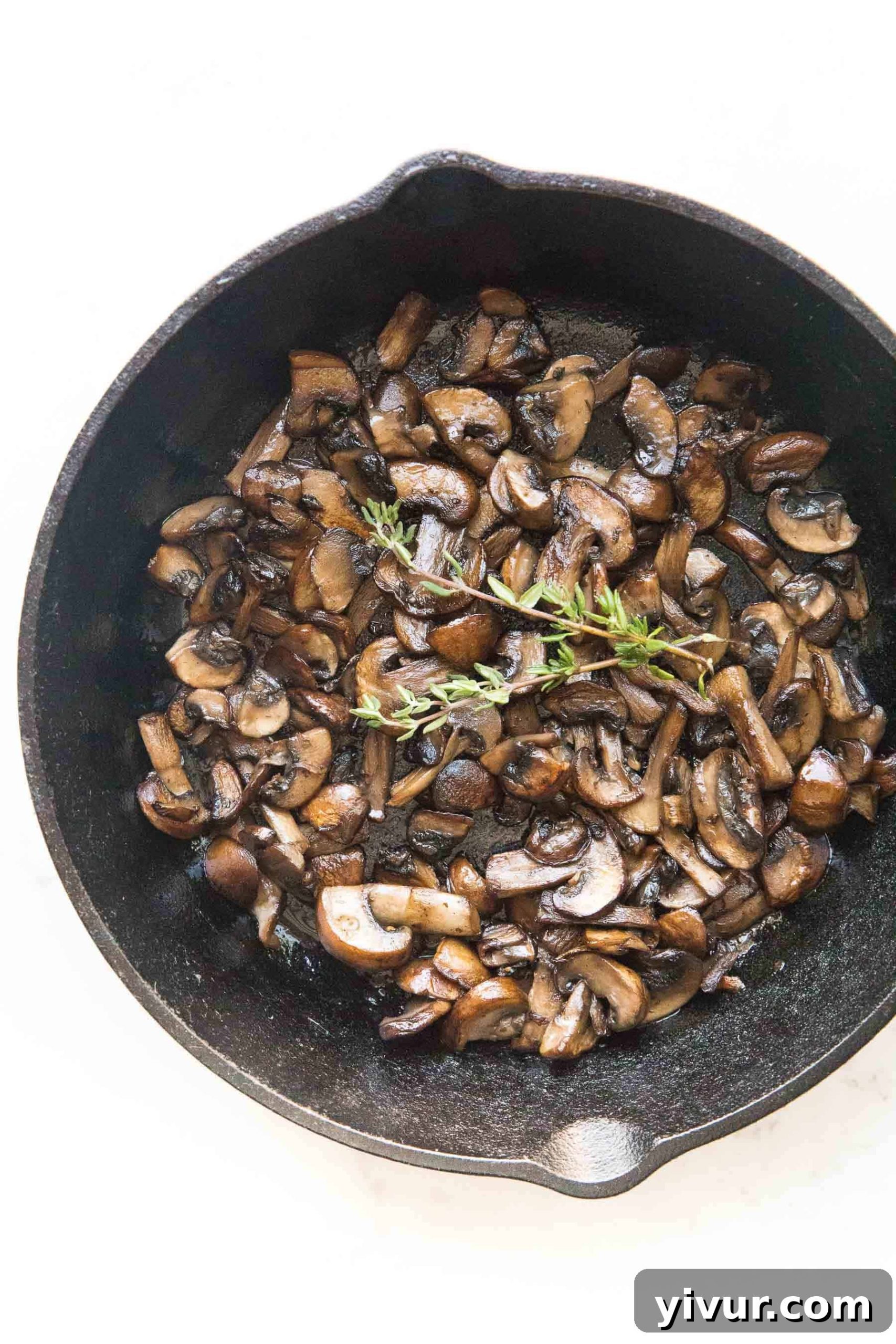 Caramelized and golden brown sauteed mushrooms in a cast iron skillet, perfect for Whole30 and Keto diets.