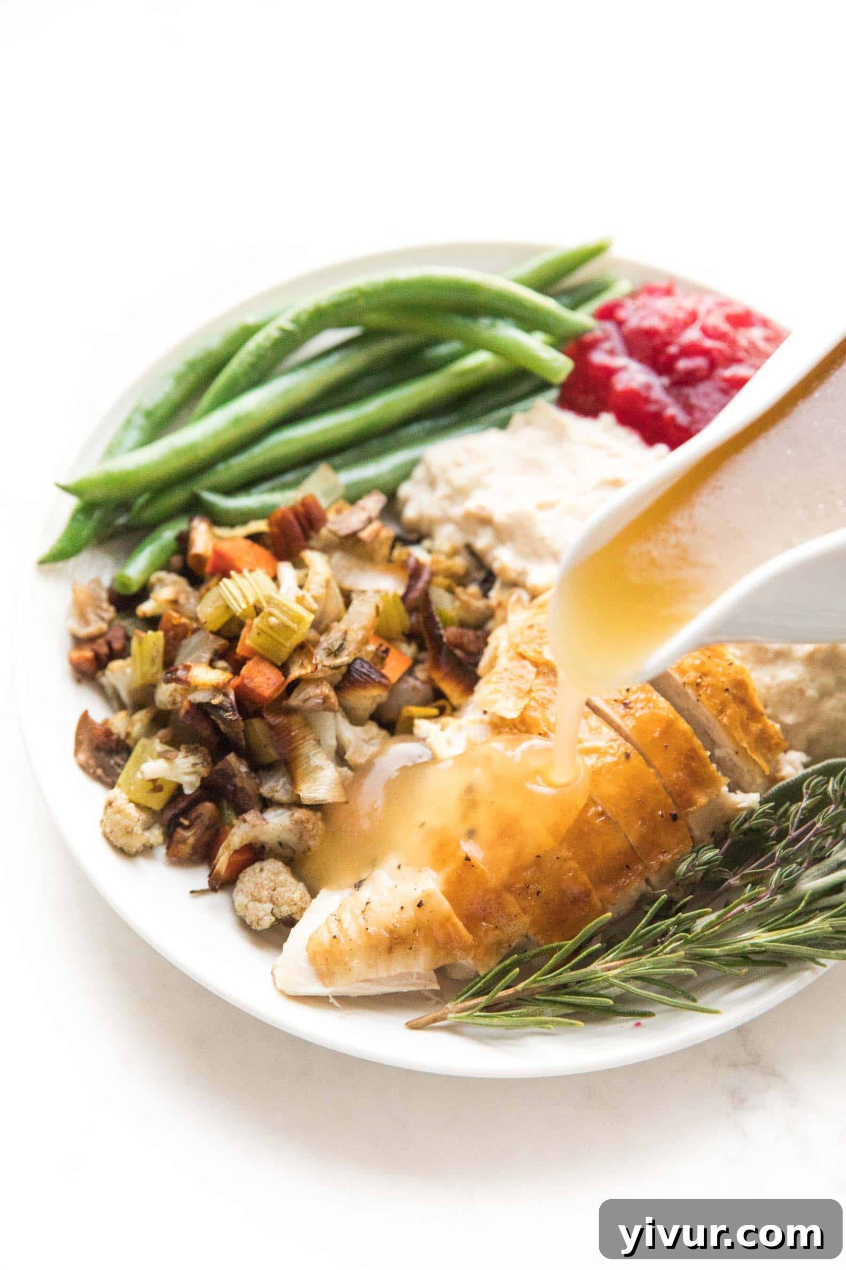 keto stuffing made with fresh herbs, chicken broth, roasted vegetables, pecans, cauliflower, and olive oil on a thanksgiving plate with other low carb mains and sides.
