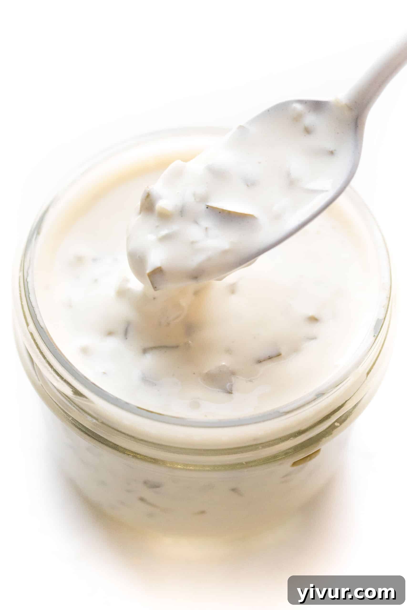 Fresh homemade tartar sauce in a small mason jar, garnished with dill and lemon, ready to be served with seafood