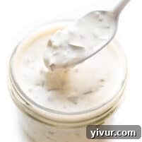 A close-up shot of the finished Whole30 and Keto Tartar Sauce in a serving bowl, garnished with fresh herbs