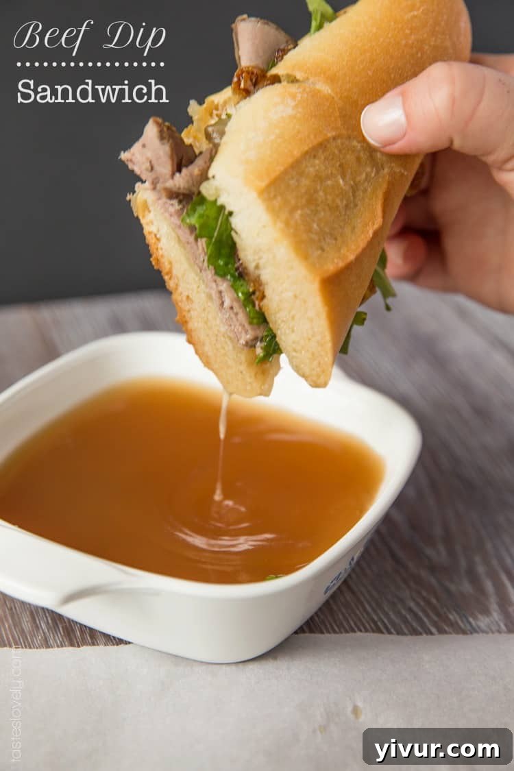 Ultimate Beef Dip Sandwich with Gruyere and Sweet Grilled Onions 2 Drippy beef dip sandwich with gruyere cheese and grilled onions on a cutting board, ready to be enjoyed.