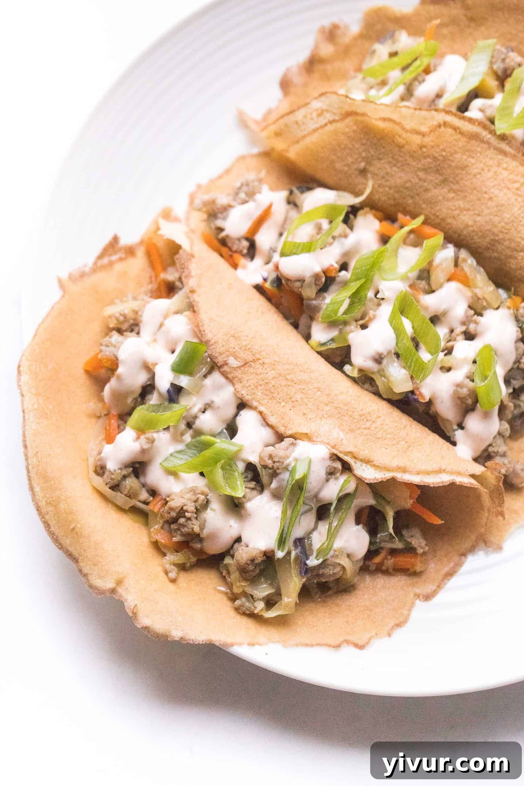 Delicious Mu Shu Pork served in cauliflower wraps topped with a generous drizzle of sriracha mayo