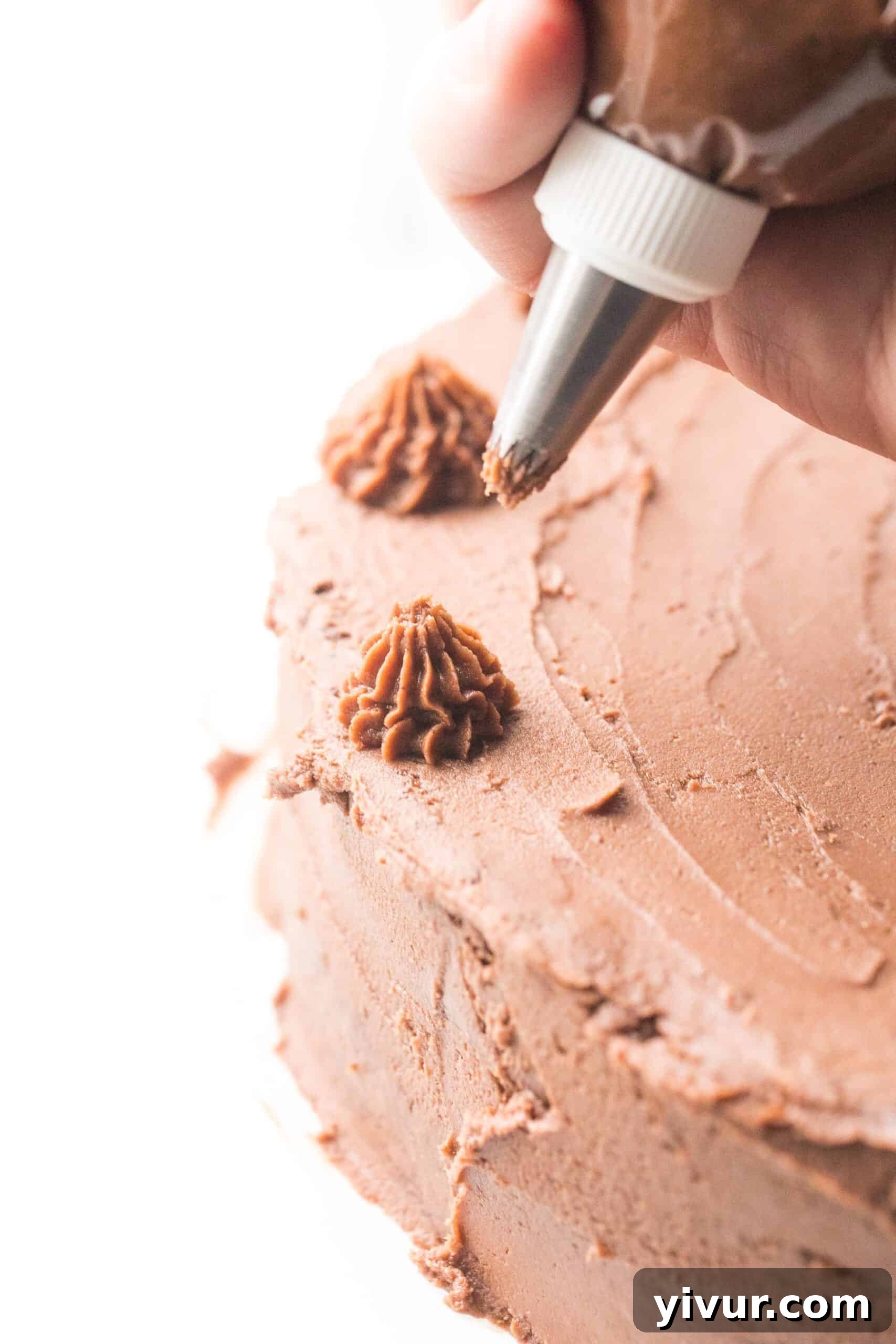 Creamy Keto Dairy Free Mint Chocolate Frosting 2 Piping chocolate frosting onto a cake