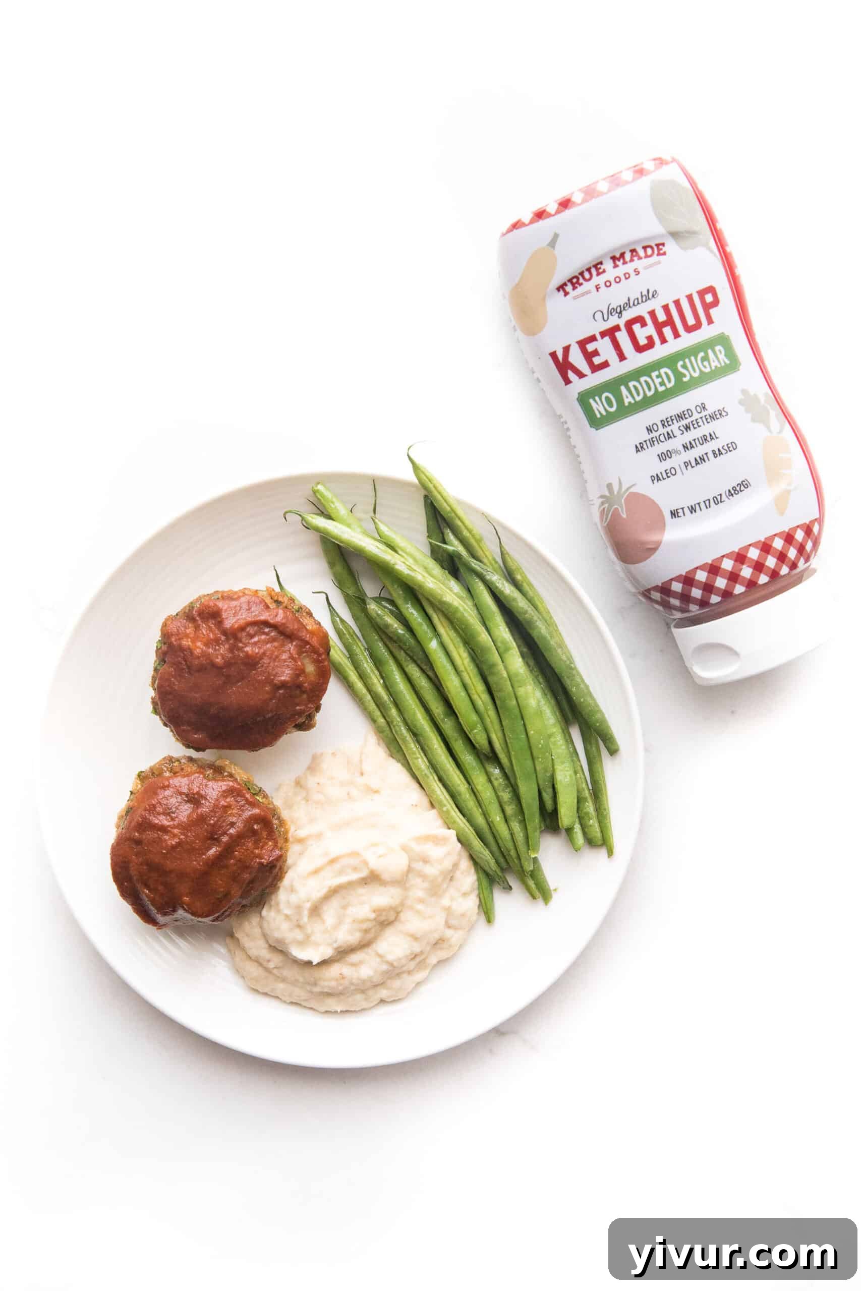 Quick Keto Meatloaf Muffin Bites 3 Close-up of fresh ingredients for keto meatloaf muffins, including ground beef, onions, garlic, almond flour, and a bottle of sugar-free ketchup, ready for mixing.