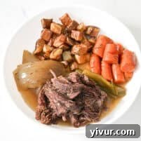 healthy instant pot pot roast on a white plate with vegetables