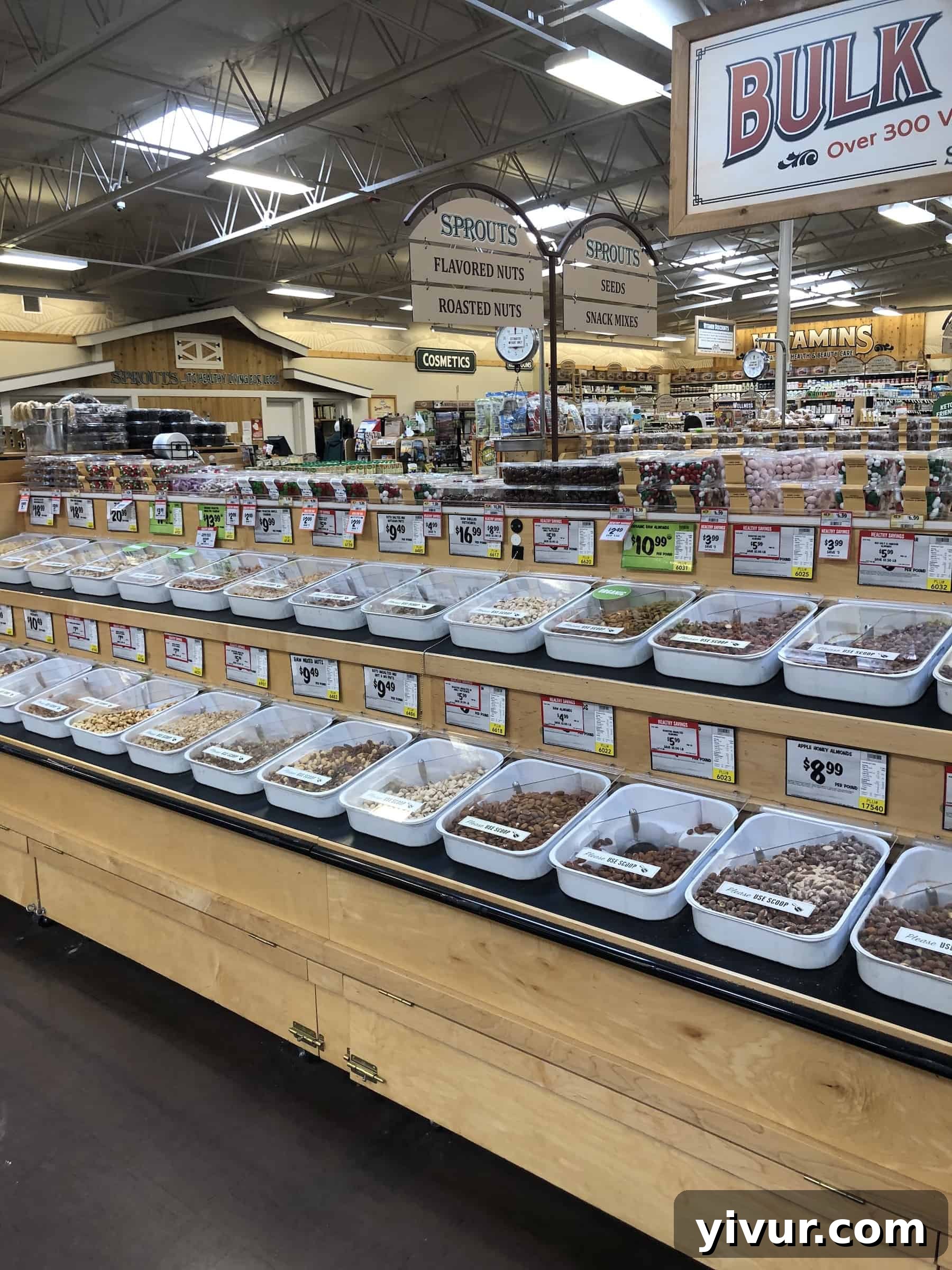 A well-stocked bulk food department at Sprouts, featuring bins of nuts, seeds, grains, and spices.