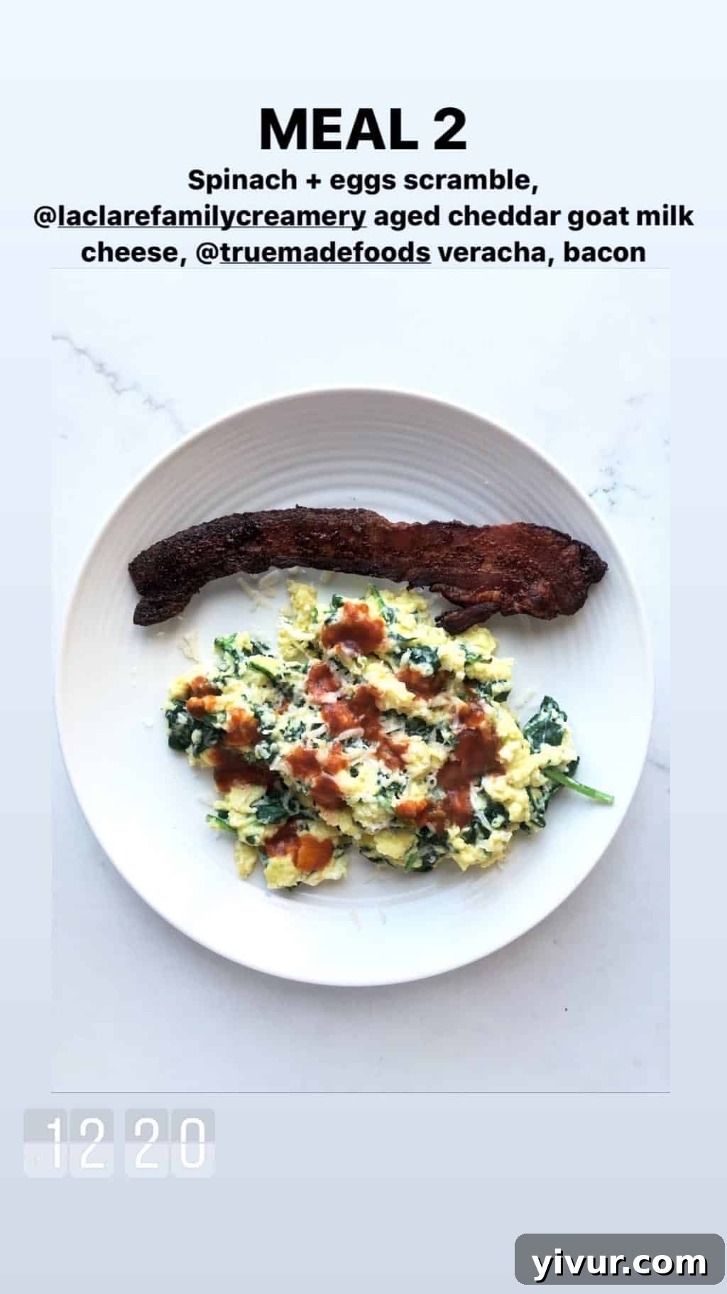 December 2019 Clean Keto and Whole30 Food Diary 12 A neatly plated spinach and egg scramble, featuring melted goat milk cheddar, a drizzle of True Made Foods Veracha, and crispy bacon slices.