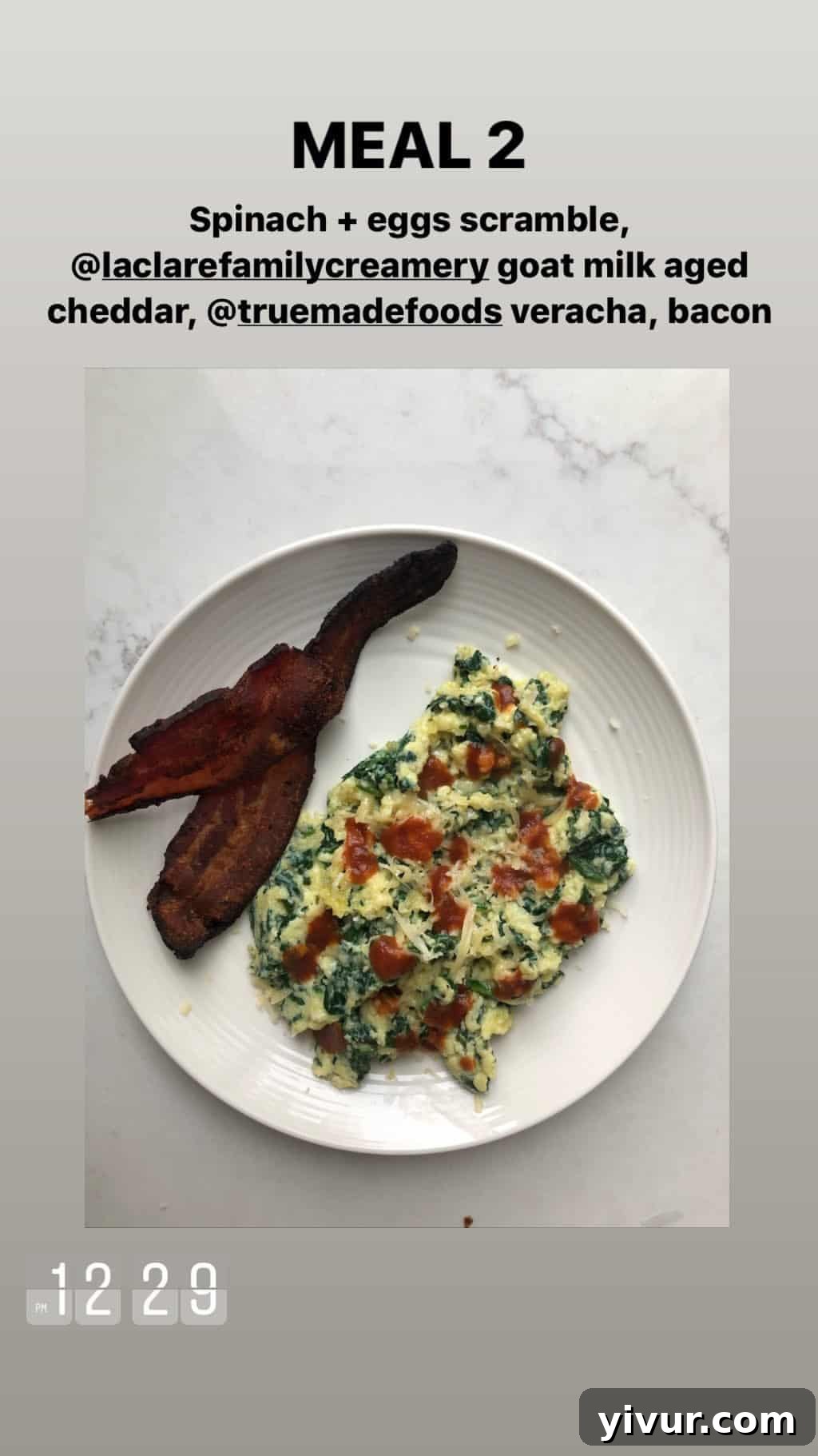 December 2019 Clean Keto and Whole30 Food Diary 4 A vibrant breakfast plate featuring a spinach and egg scramble, topped with goat milk cheddar and True Made Foods Veracha, alongside crispy bacon.