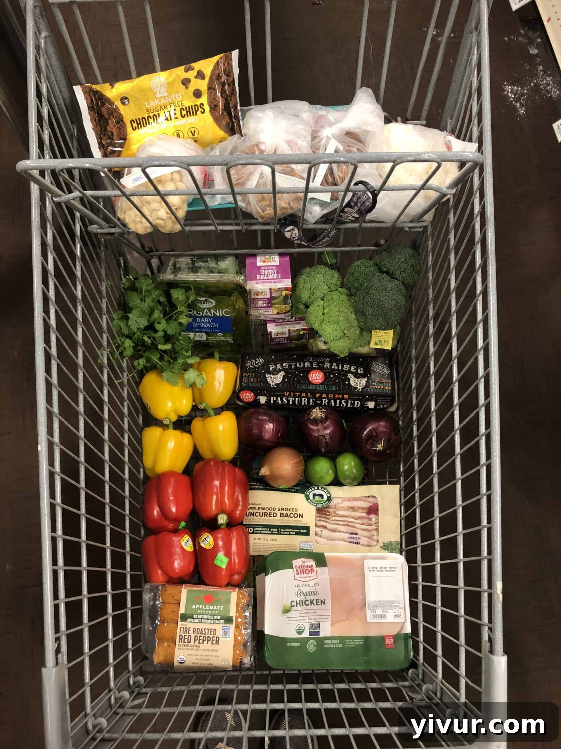 A full grocery cart overflowing with fresh organic produce, quality meats, and healthy pantry staples, representing a cost-effective Whole30 and Keto grocery haul.