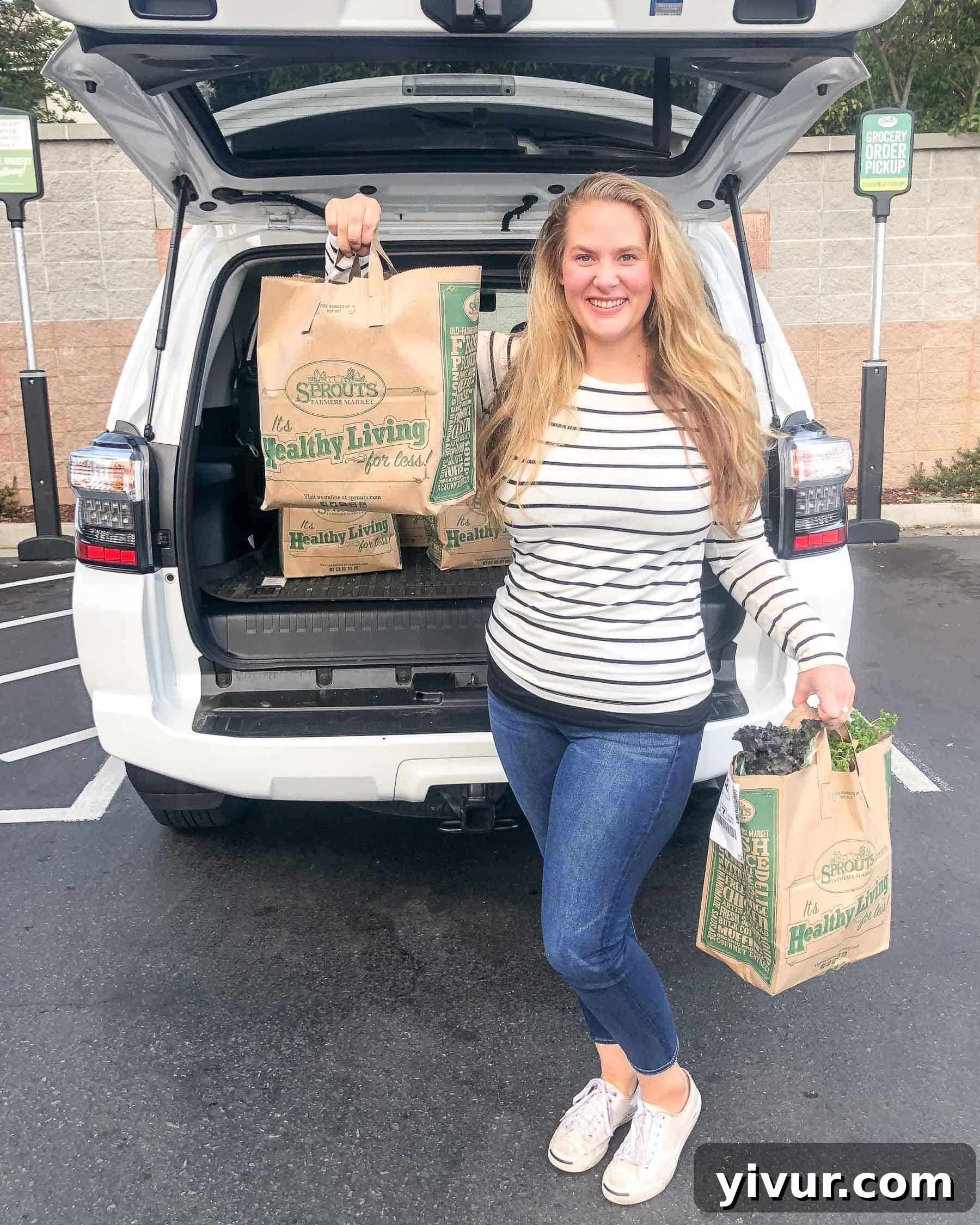 girl holding sprouts grocery delivery by a car