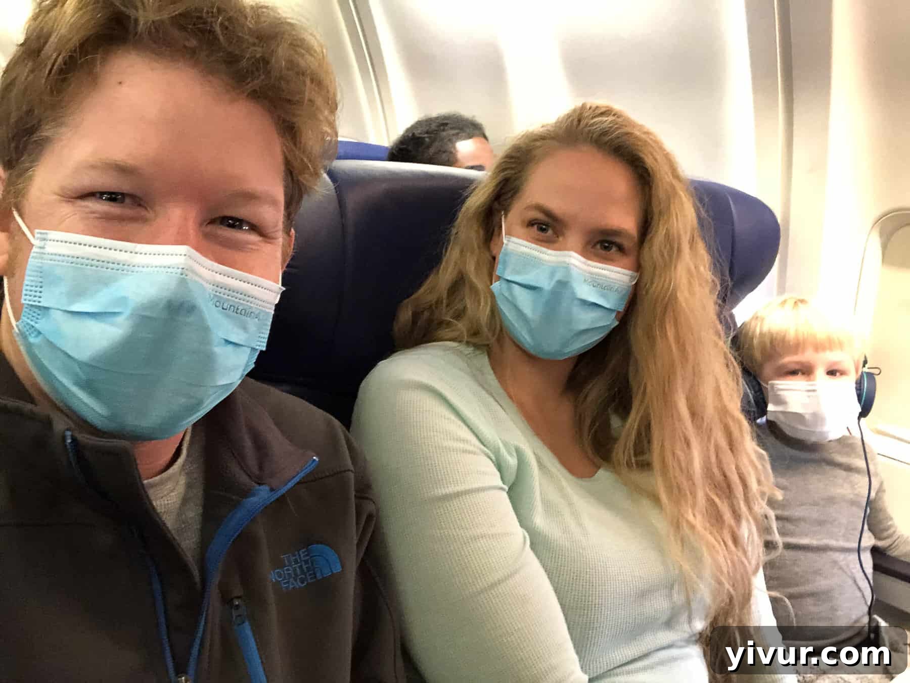 4 Yaşındaki Evladım Neden Alçıda ve Tekerlekli Sandalyede 24 Our family wearing medical masks while flying to St. Louis for Josh's patellar dislocation surgery, framed as a superhero adventure to keep him safe and happy before the procedure.
