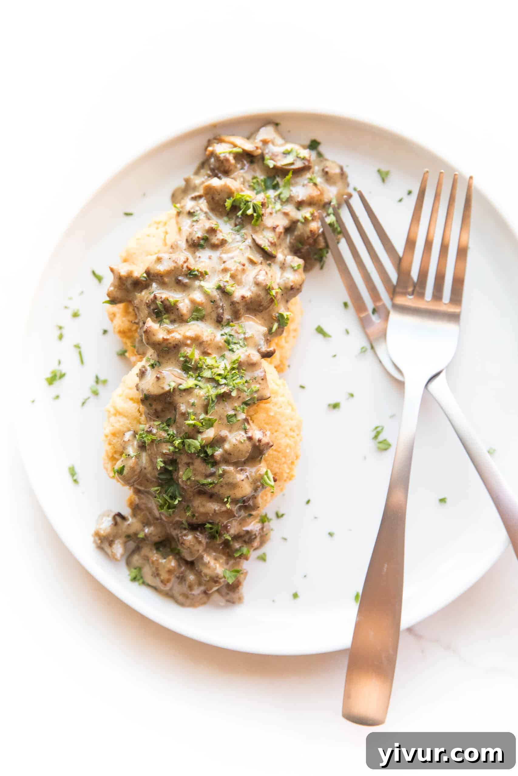 KETO BISCUITS AND GRAVY ON A WHITE PLATE