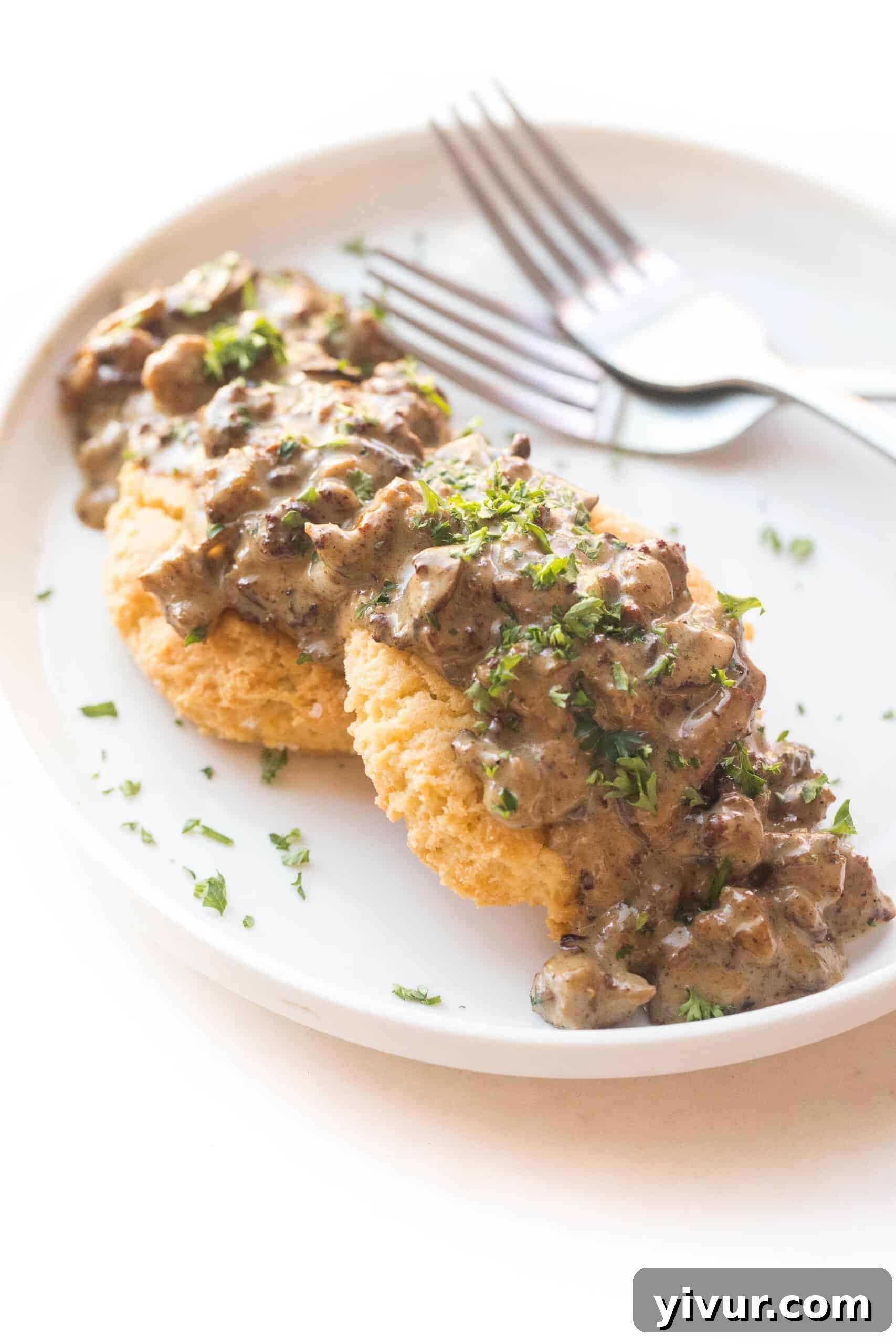 KETO BISCUITS AND GRAVY ON A WHITE PLATE