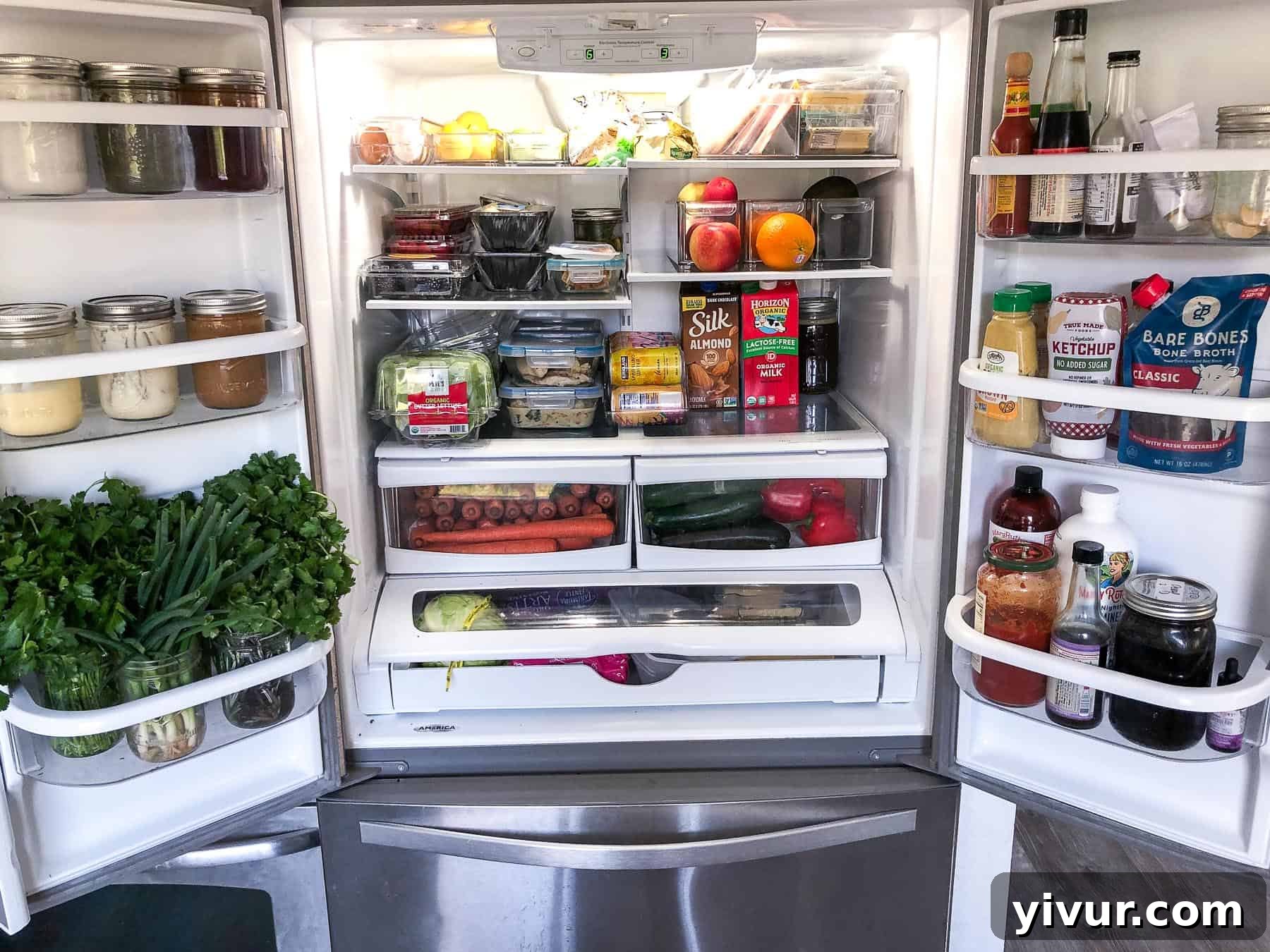 A neatly organized refrigerator stocked with Whole30 and Keto compliant foods, fresh ingredients, and prepared meal preps.