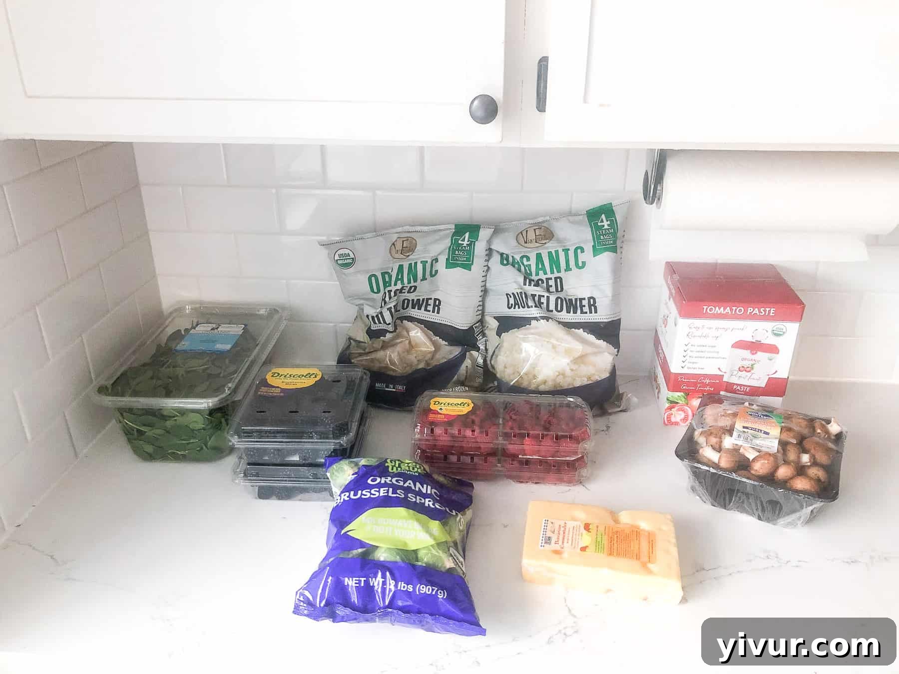 A snapshot of a Costco grocery haul, featuring bulk Whole30 and Keto compliant items like organic eggs, large packs of vegetables, and pantry staples.