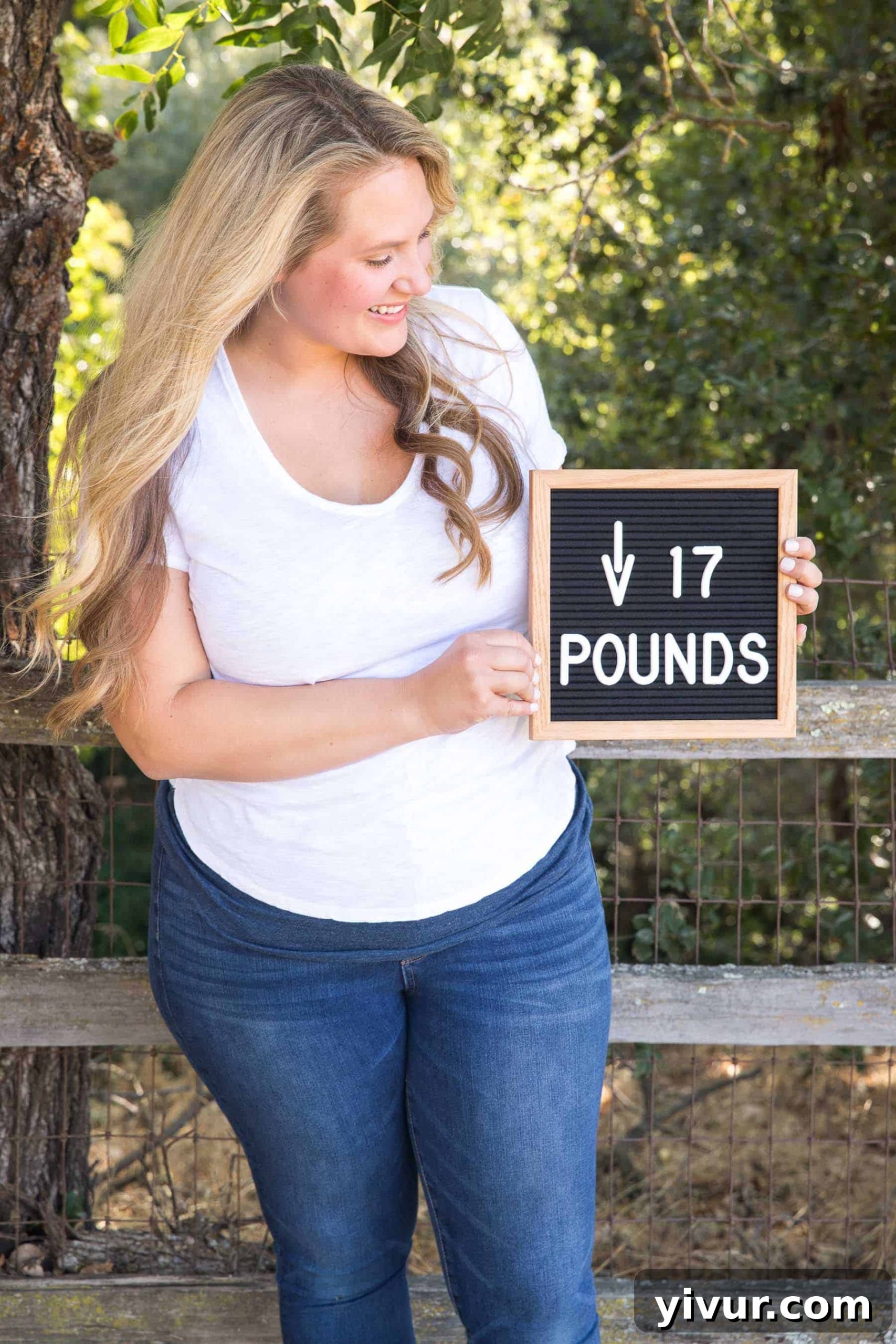 Blonde woman holding a sign that proudly states "Down 17 Pounds" after her first month on clean keto.