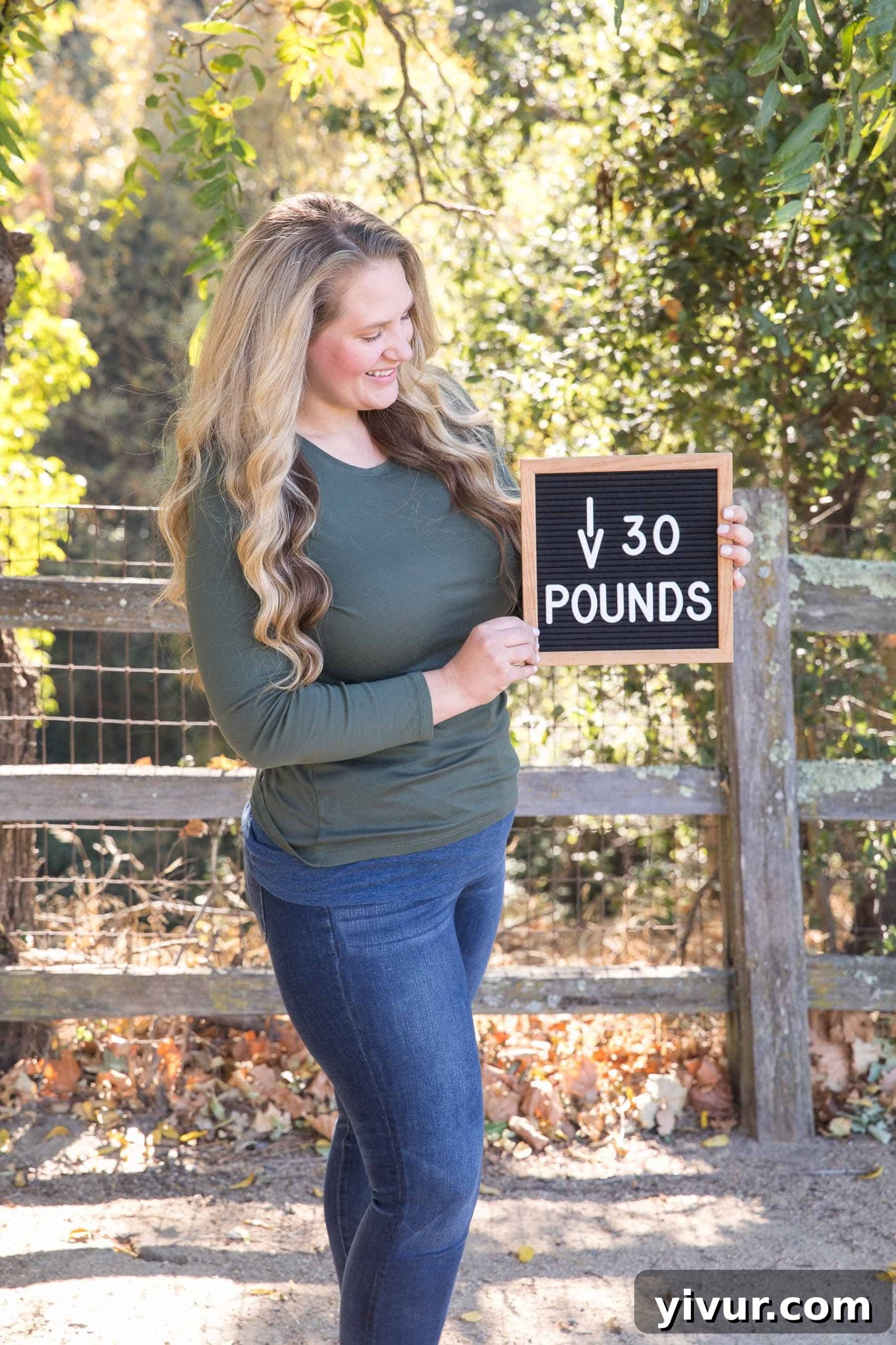 Woman holding a sign indicating a total weight loss of 30 pounds on her clean keto journey.