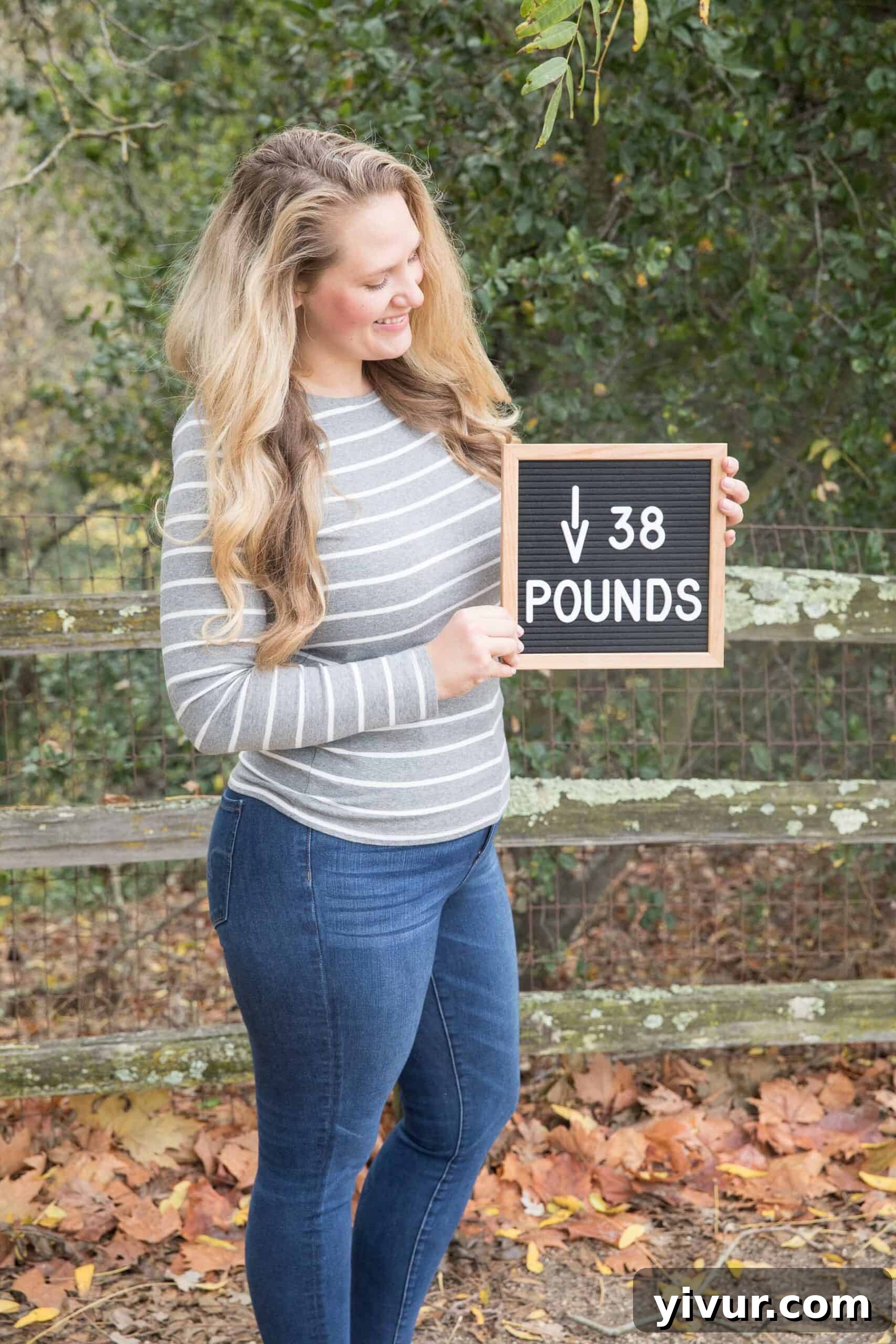 Girl holding a letterboard proudly stating 'Down 38 Pounds' on her weight loss journey with clean keto.