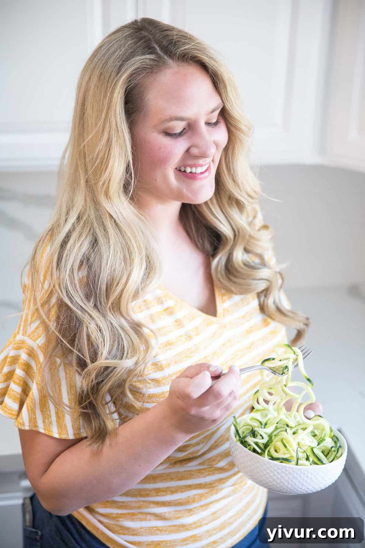 A woman smiling and holding a healthy green smoothie, representing a positive approach to diet and lifestyle.