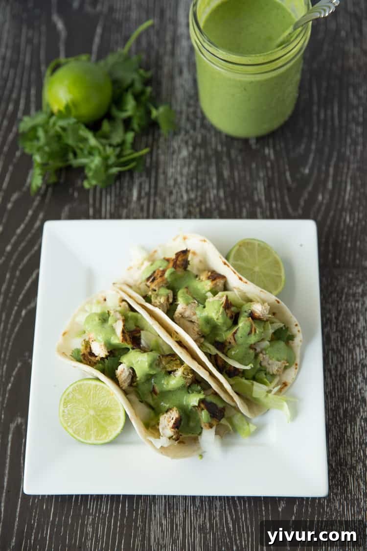 Close-up of a chicken taco showcasing tender chicken, fresh lettuce, and a generous drizzle of cilantro lime ranch