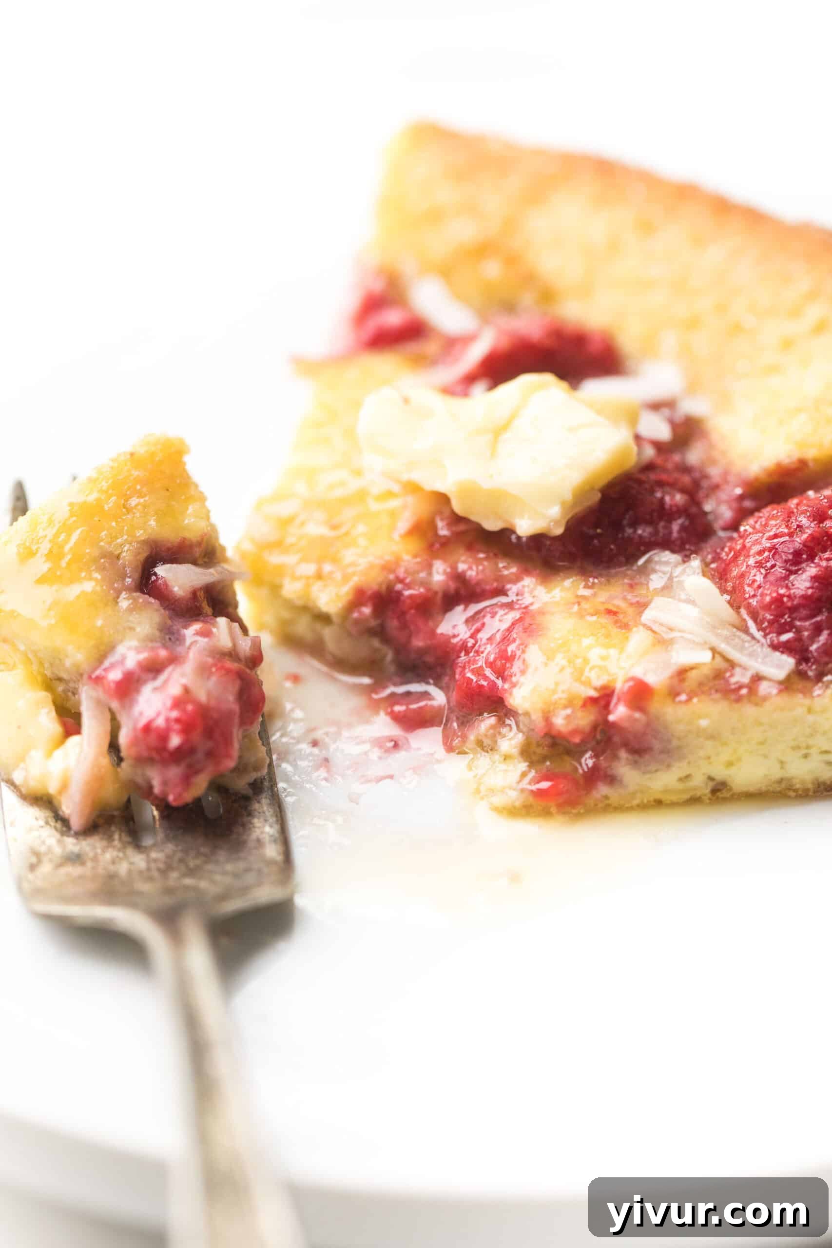 A slice of Keto Dutch Baby Pancake with raspberries on a plate