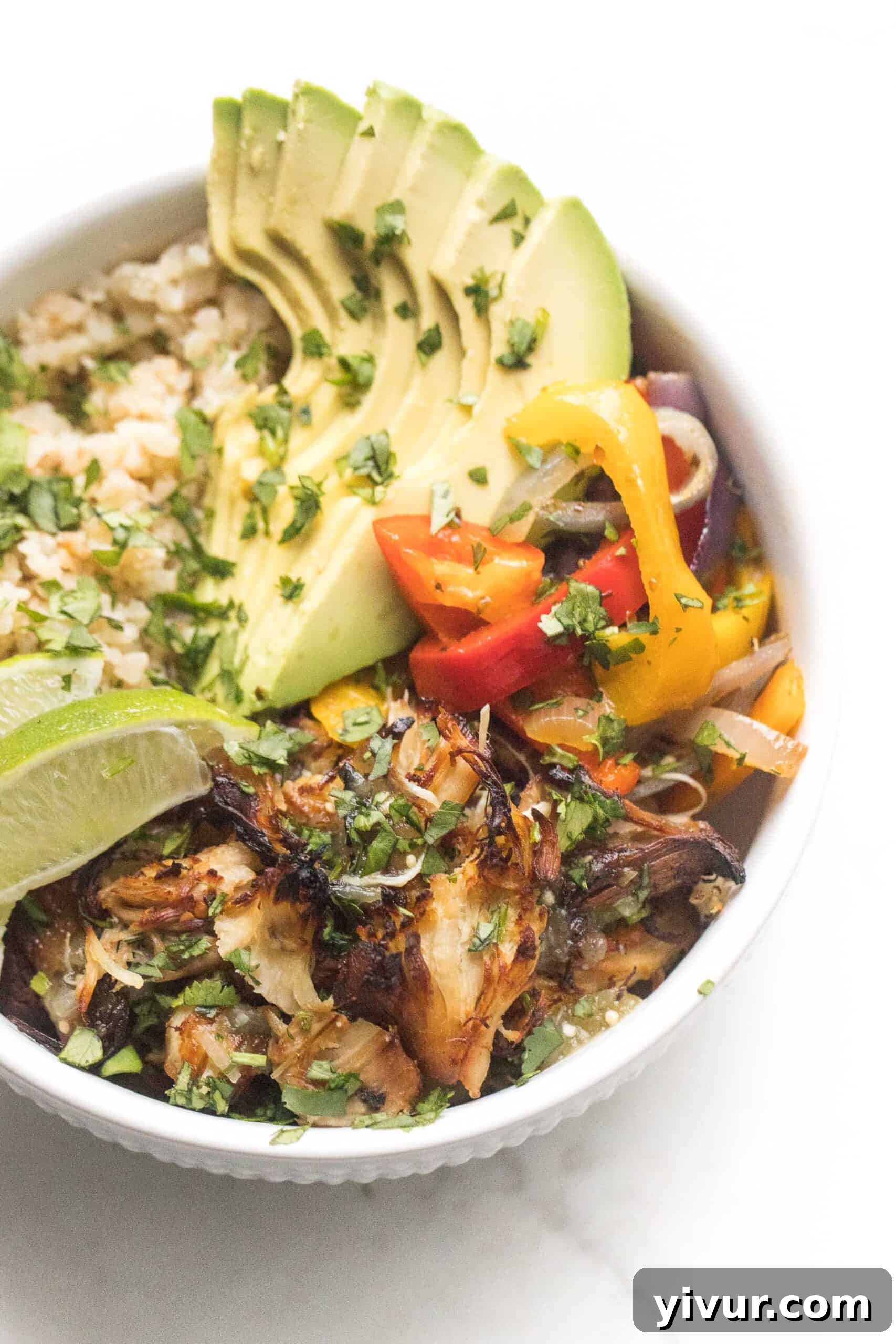 Crispy Salsa Verde Chicken served in a vibrant burrito bowl with fresh toppings on a white background
