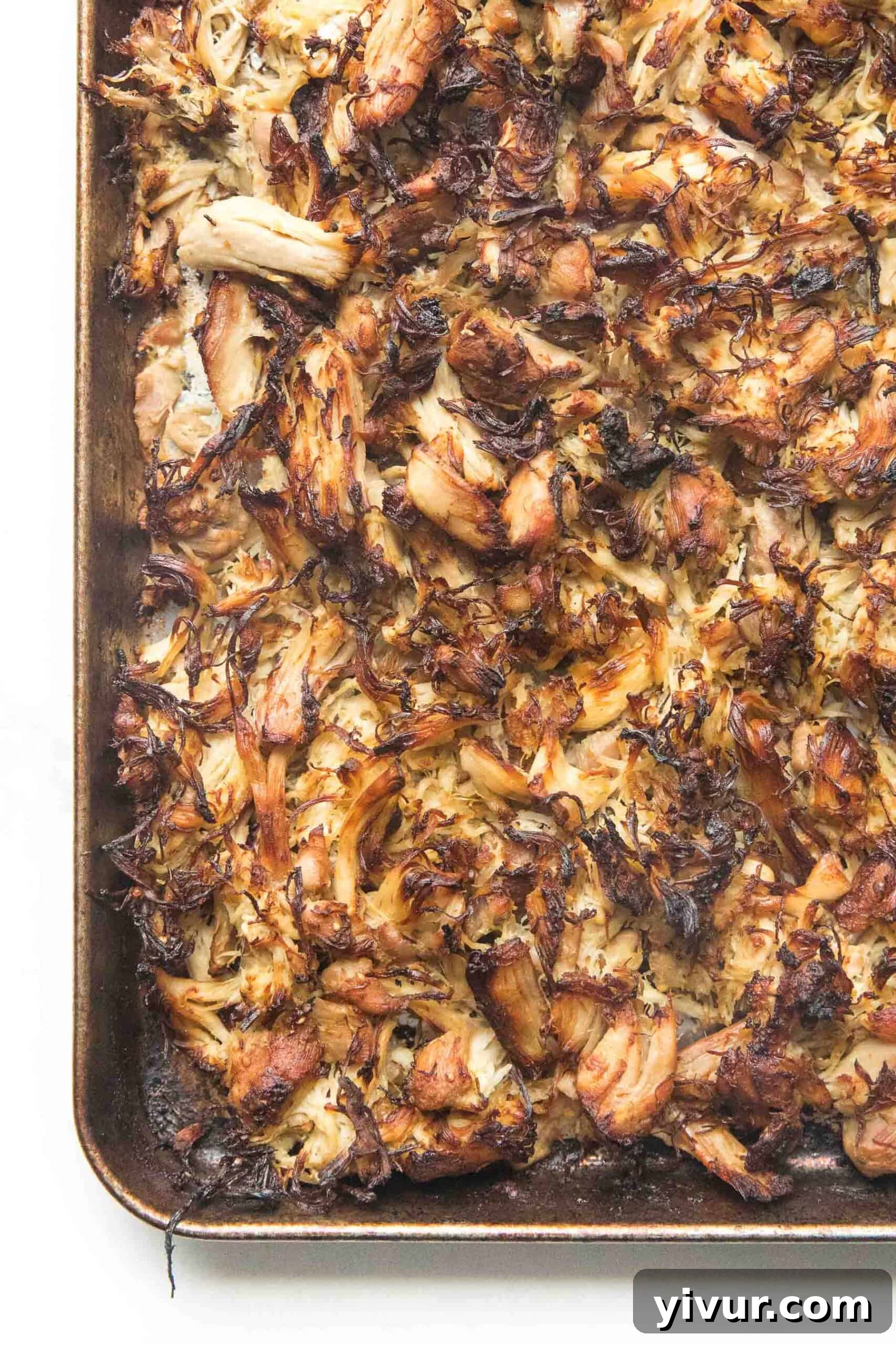 Crispy verde chicken shown on a rimmed baking sheet fresh from the oven