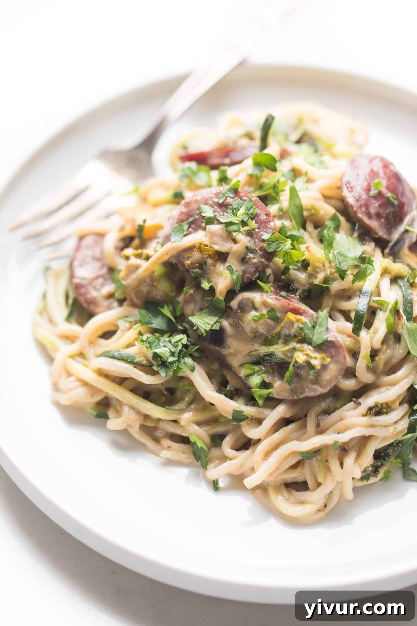 creamy pasta on a white plate and white background, ready to be enjoyed