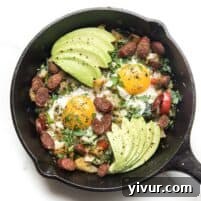 KETO low carb no potato breakfast hash with eggs and avocado in a cast iron skillet on a white background