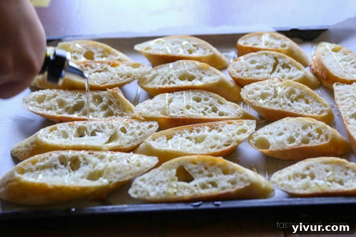 Bruschetta-12: Bread slices arranged on a baking sheet, drizzled with olive oil