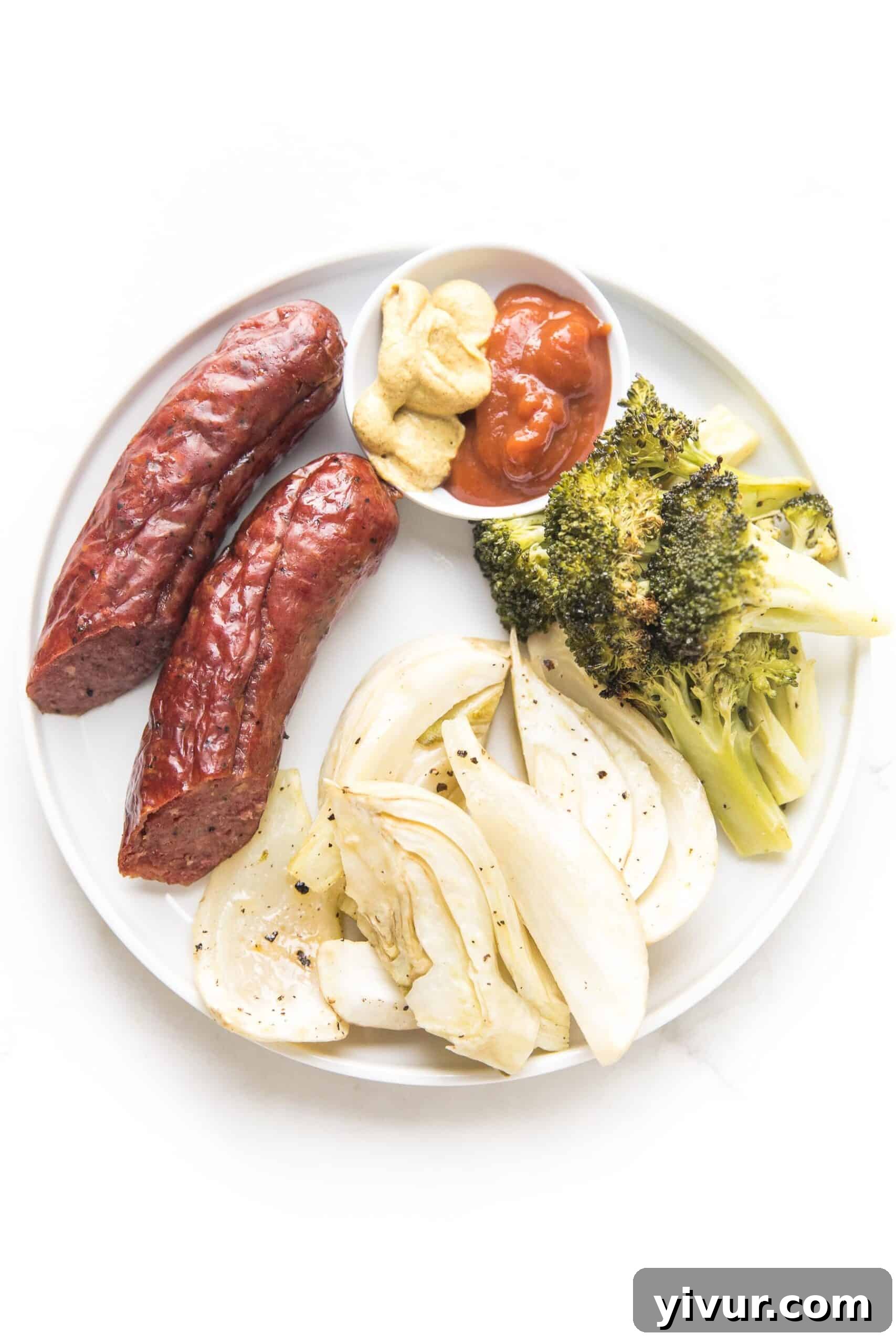 Sausage, roasted fennel, and broccoli served on a white plate