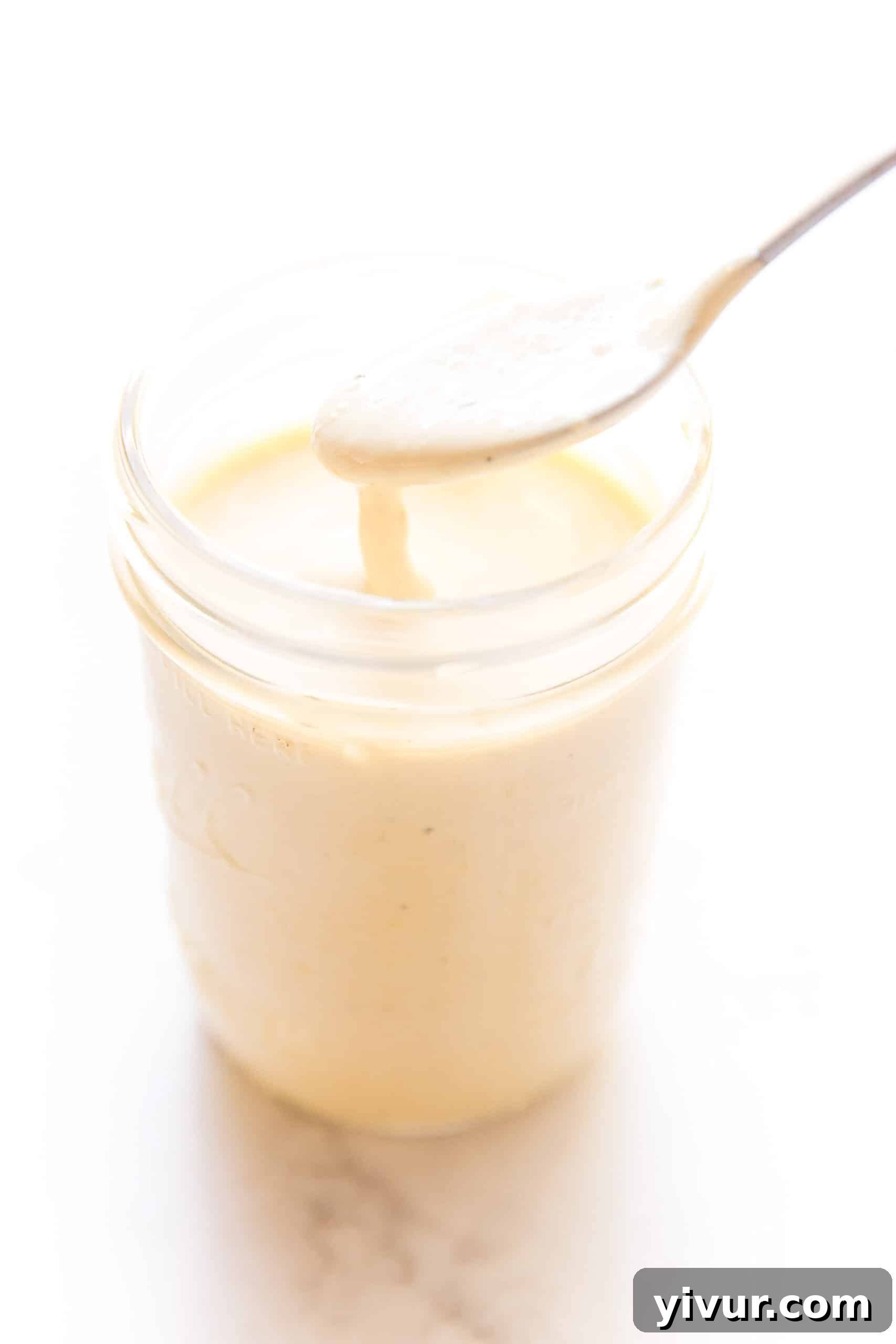 The Ultimate Dairy-Free Keto Caesar Dressing for Whole30 4 Dairy-free keto Caesar dressing freshly poured into a clean mason jar, sealed for convenient storage in the refrigerator on a crisp white background.