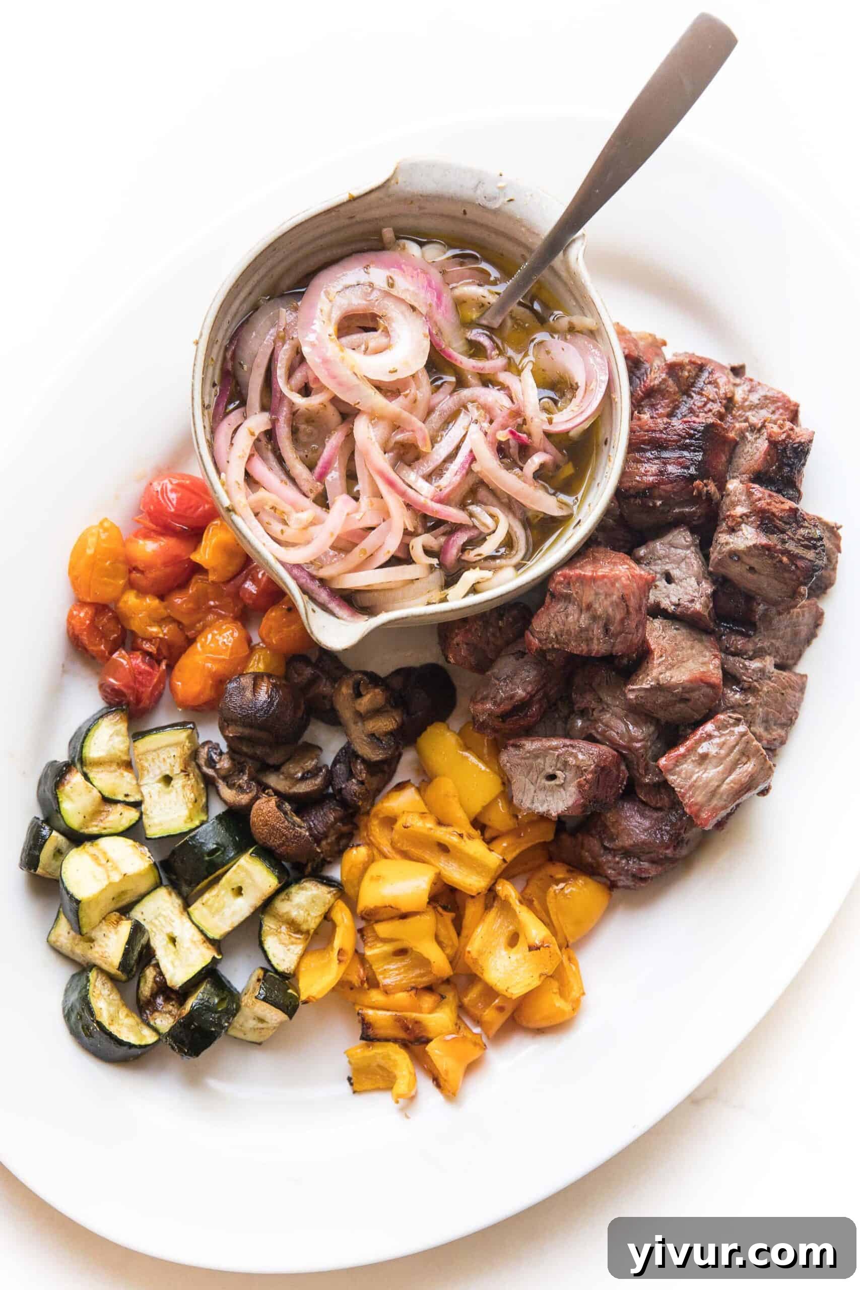 A close-up view of two platters of grilled steak and vegetable skewers, highlighting the rich colors and textures of the meal