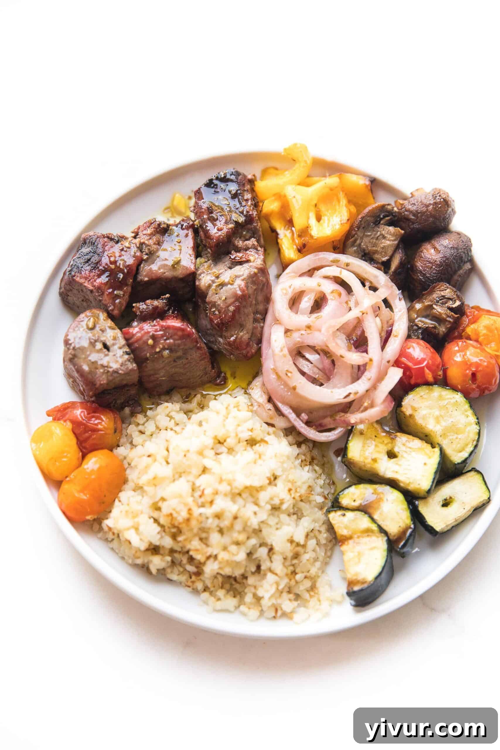 A beautifully arranged plate featuring grilled steak and vibrant vegetable kabobs, ready to be enjoyed