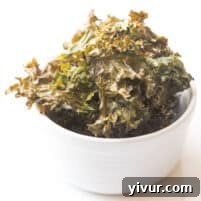 A small bowl brimming with fresh, crispy kale chips, seasoned perfectly and ready to be enjoyed as a healthy and satisfying snack.
