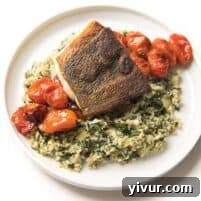 Whole30 + Keto Halibut with Spinach Artichoke Cauliflower Rice Risotto + blistered tomatoes on a white plate