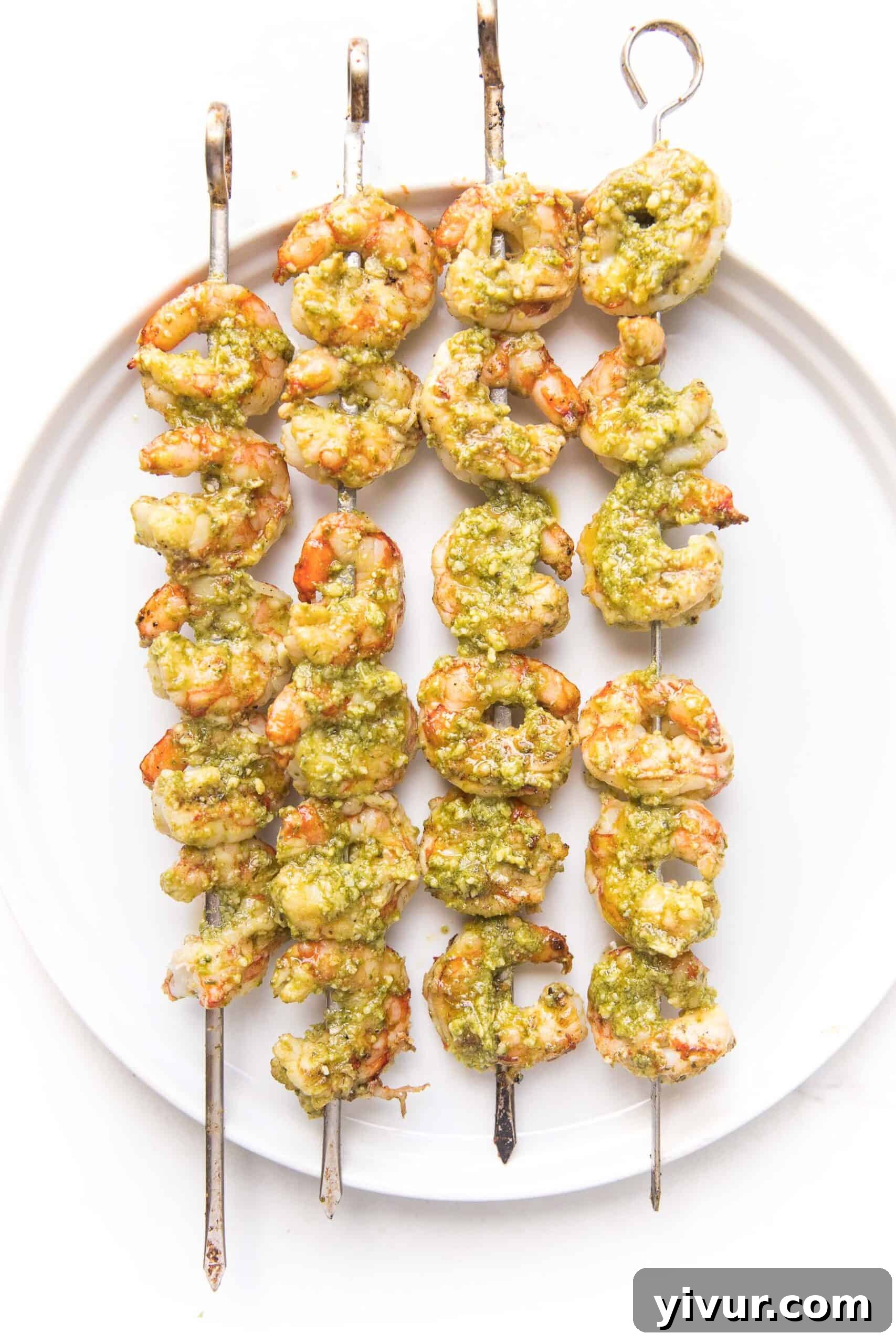 pesto shrimp kabobs on a white plate