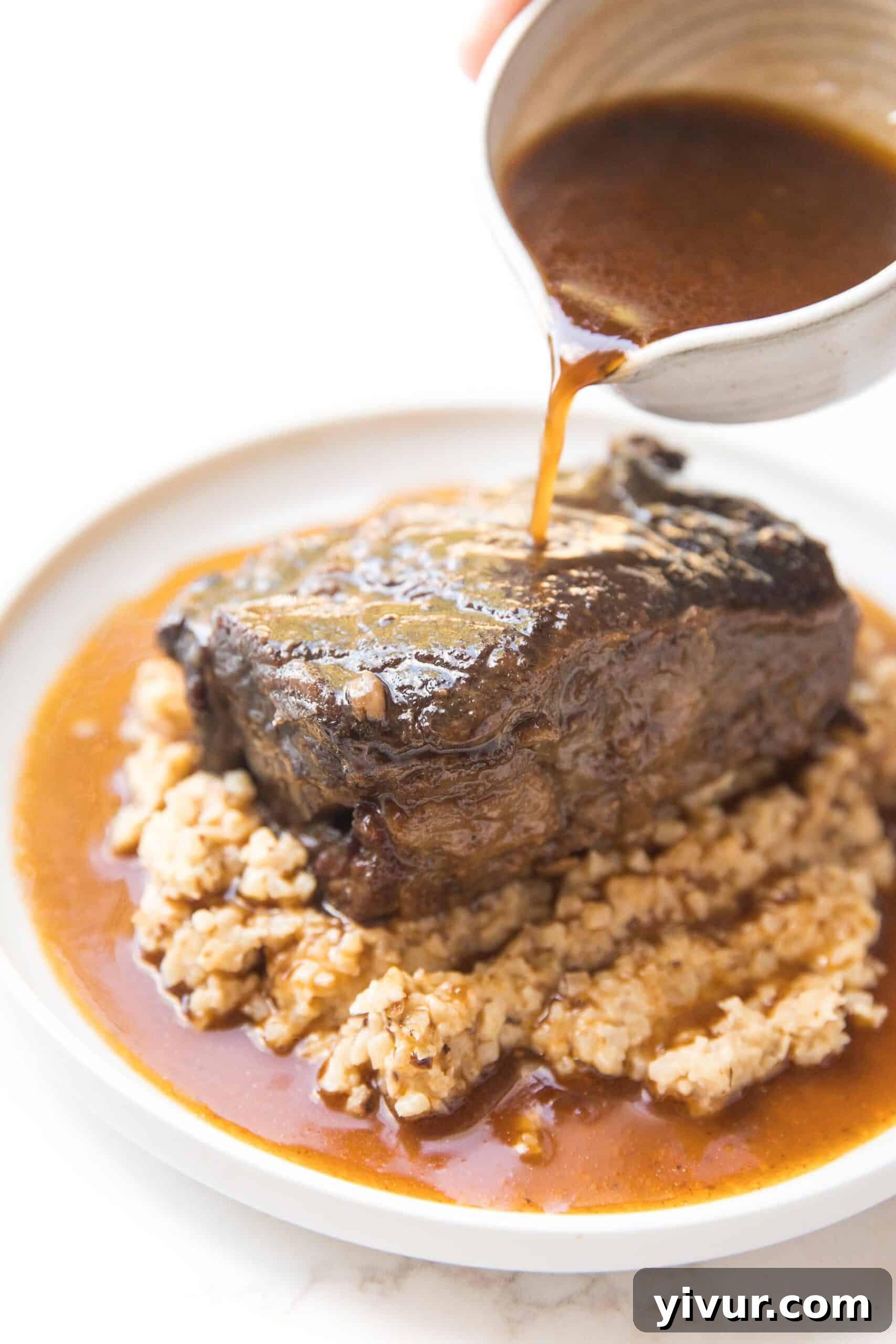 Melt-In-Your-Mouth Instant Pot Keto Short Ribs 2 Rich red wine sauce being poured over perfectly cooked, tender short ribs, highlighting their succulence.