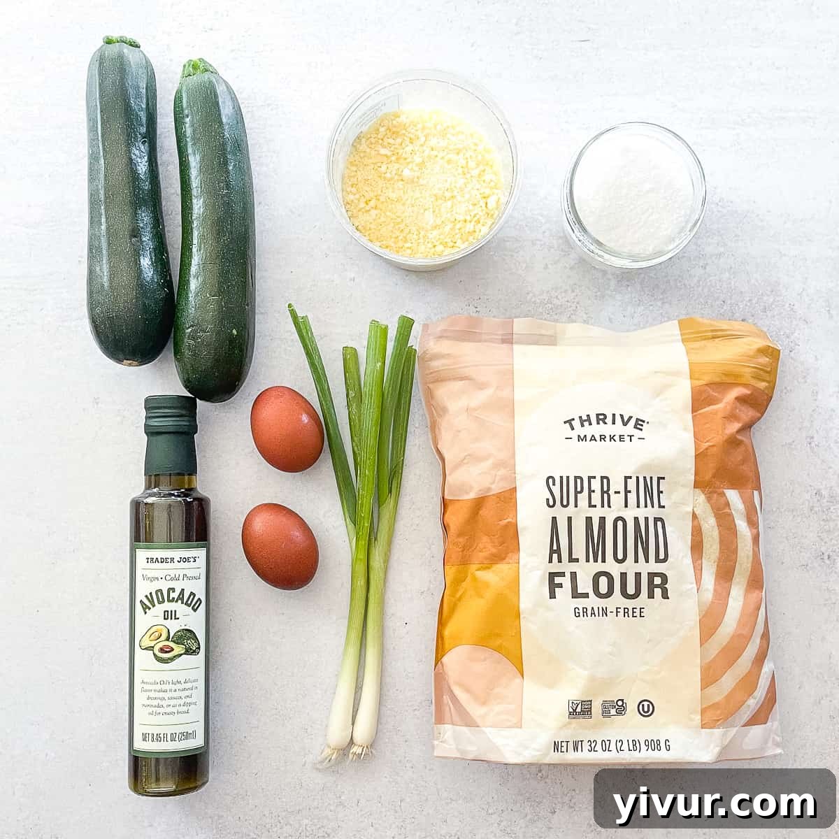 Close-up of fresh, vibrant zucchini and other ingredients like almond flour and eggs, ready to be prepared for keto zucchini fritters.