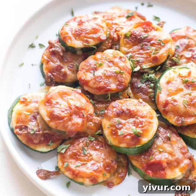 Mini keto zucchini pizza bites on a white plate, perfect for a low-carb snack or appetizer.