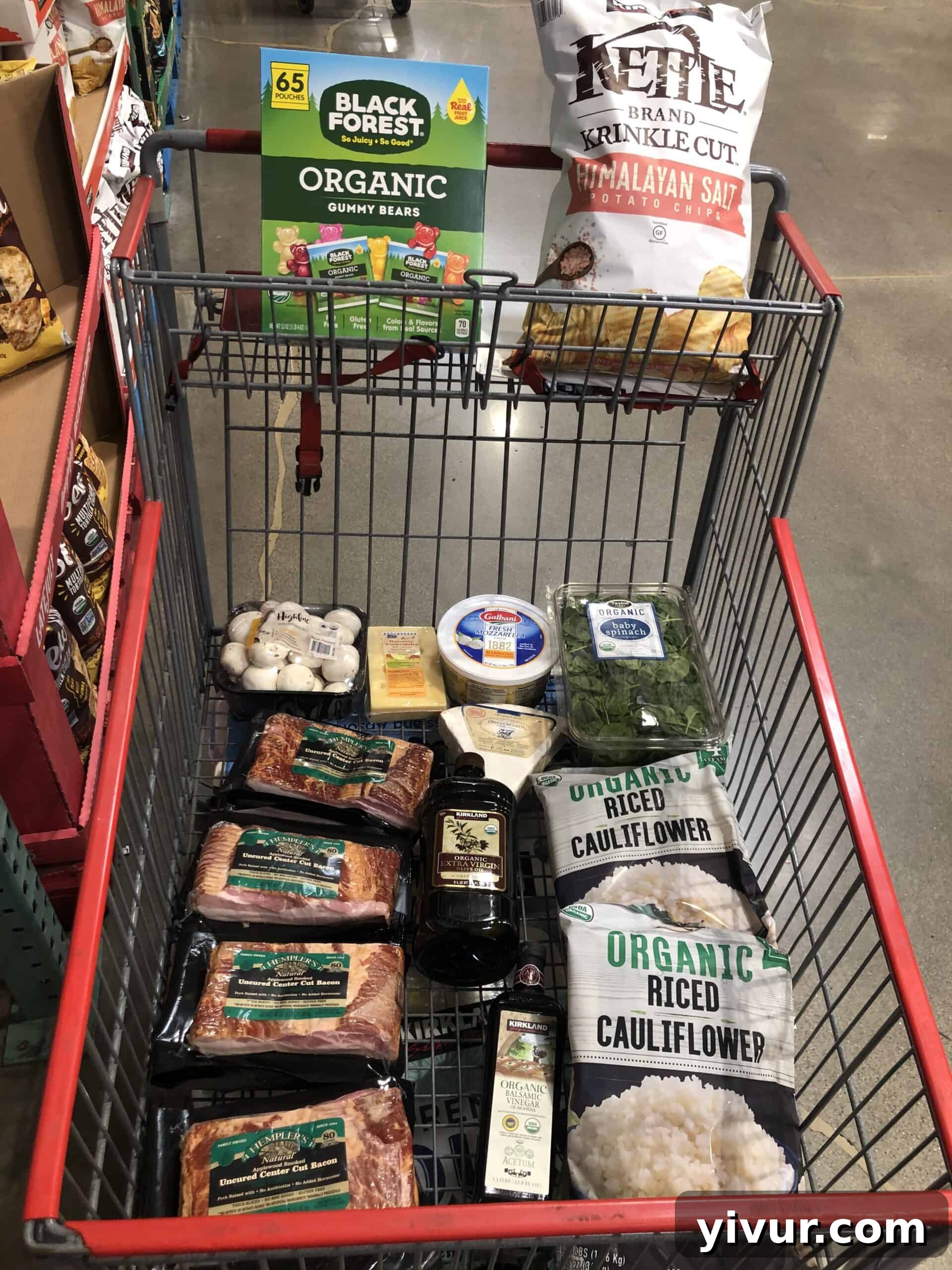 A large grocery haul from Costco, featuring bulk keto-friendly items like meats, produce, and pantry staples, organized for display.