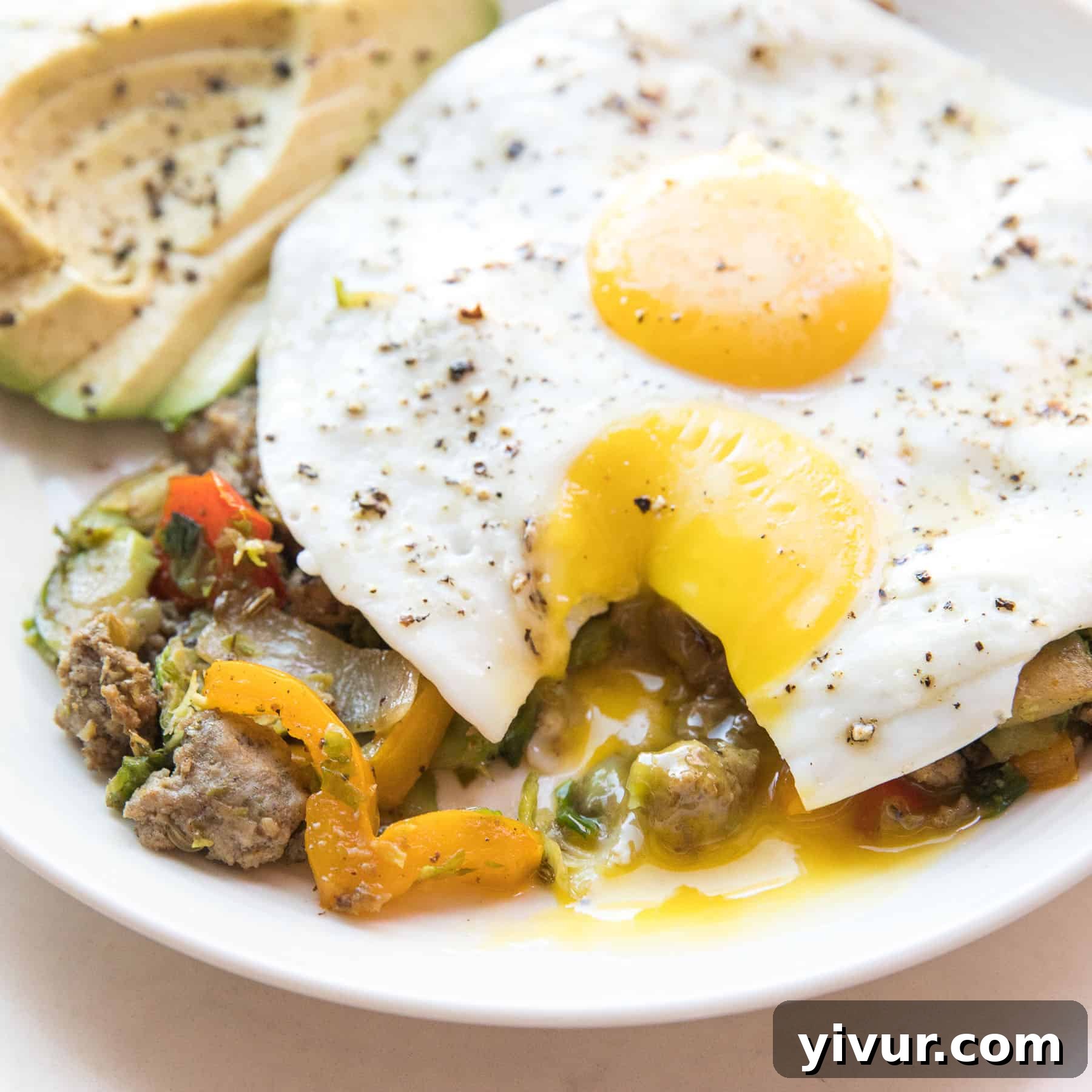 A hearty keto and Whole30 sausage and Brussels sprouts hash with fried egg on top.