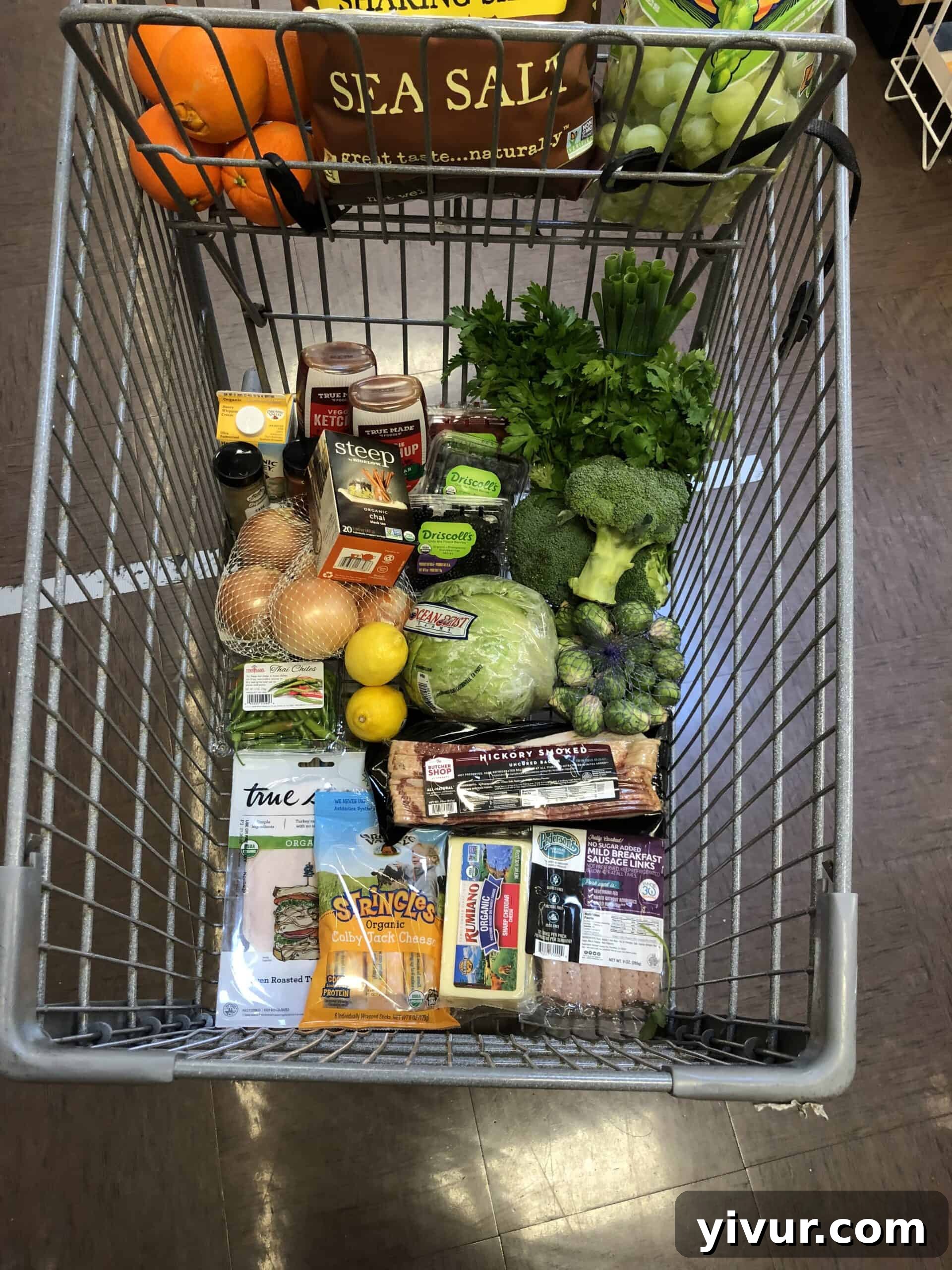 A grocery cart filled with a diverse range of fresh produce, keto-friendly snacks, and essentials from Sprouts Farmers Market, representing a typical weekly keto grocery haul.