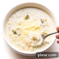 Instant Pot Keto Broccoli Cheddar Soup in a white bowl, ready to be served.