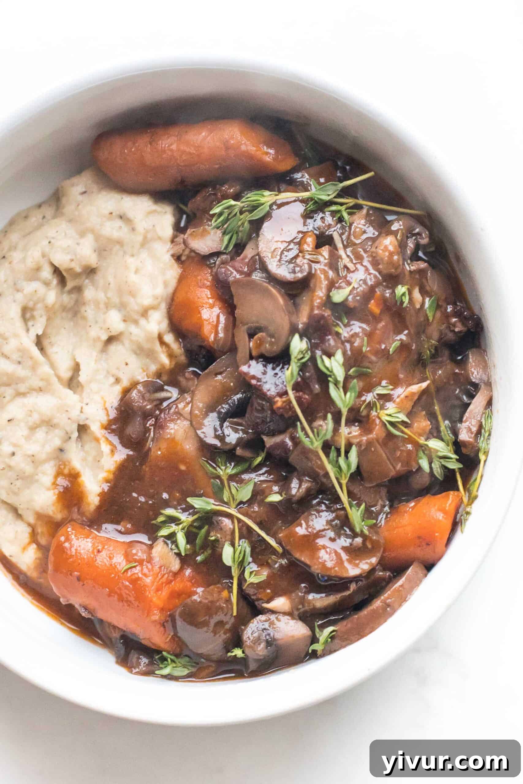 keto instant pot coq au vin with mashed cauliflower in a white bowl on a white background