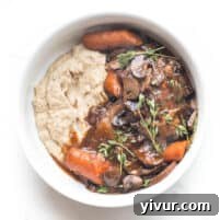 keto instant pot coq au vin with mashed cauliflower in a white bowl on a white background