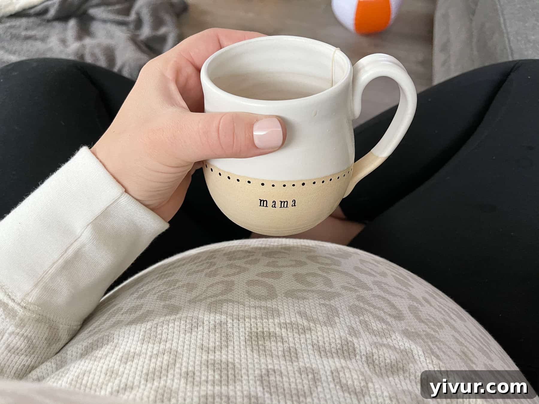 Pregnant belly at 35 weeks with a hot beverage in a 'mama' mug