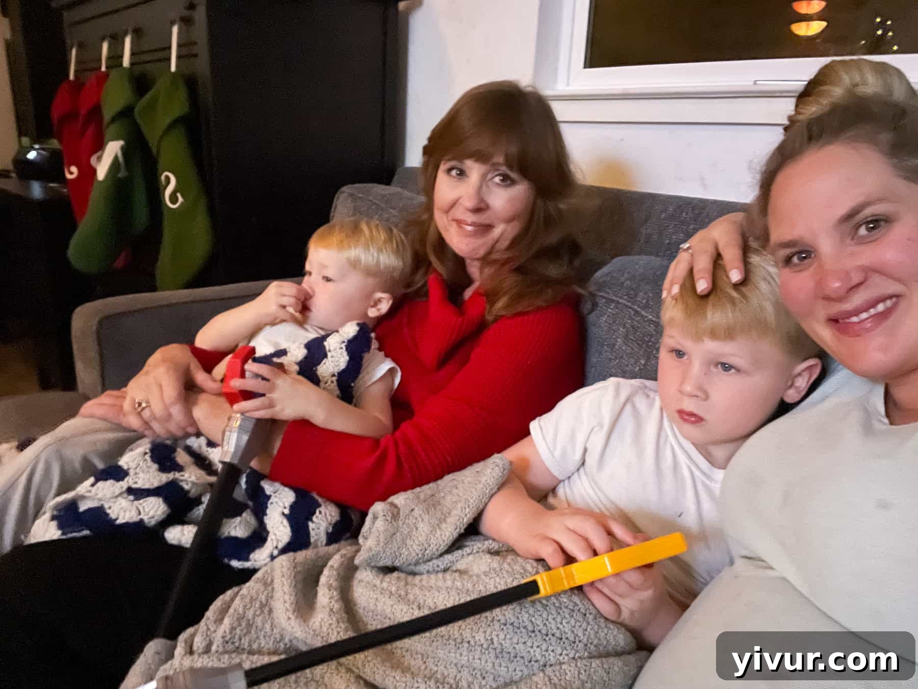 Family snuggled on a couch watching Christmas movies