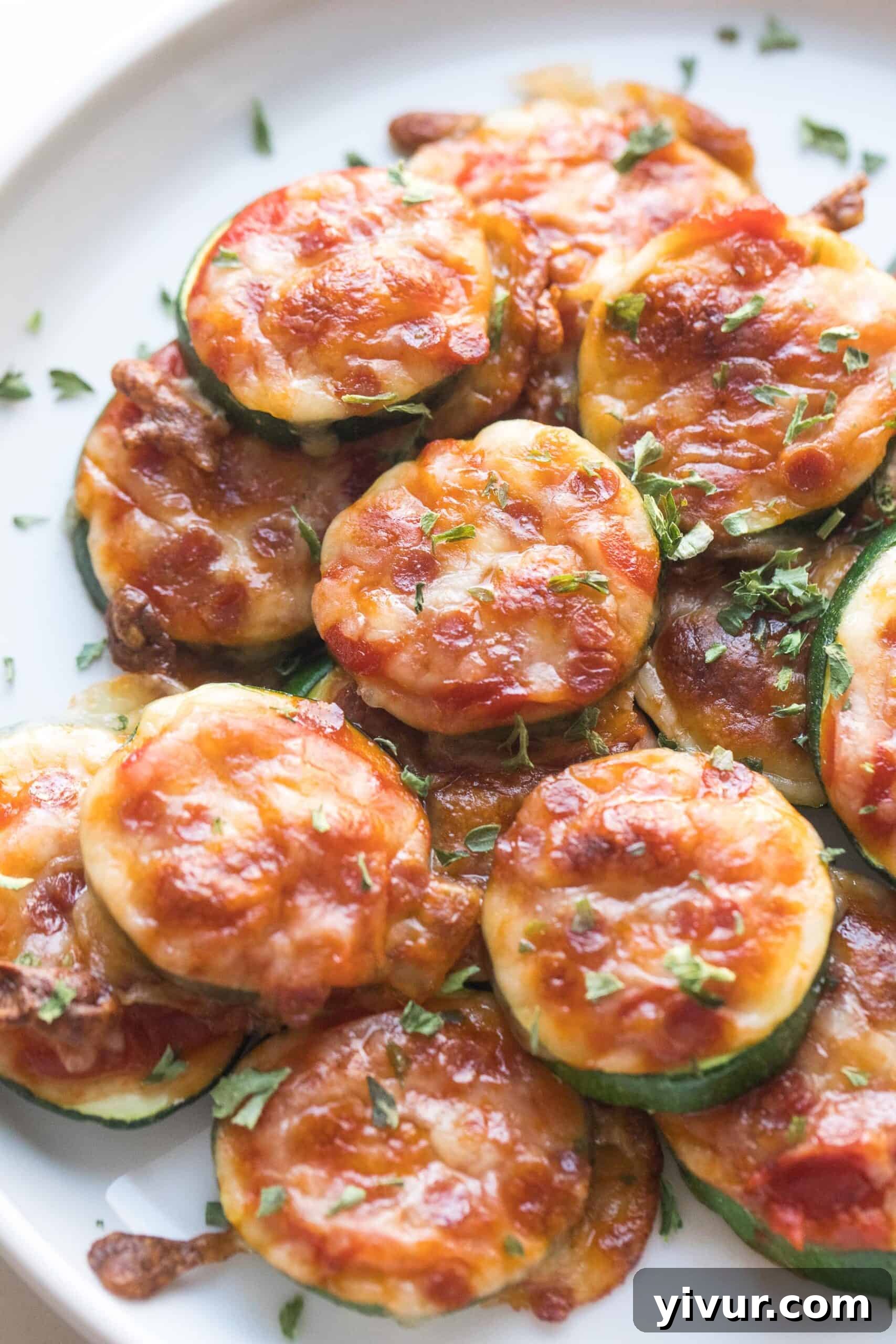 keto mini zucchini pizza bites on a white plate and background