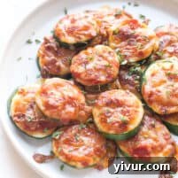 keto mini zucchini pizza bites on a white plate and background